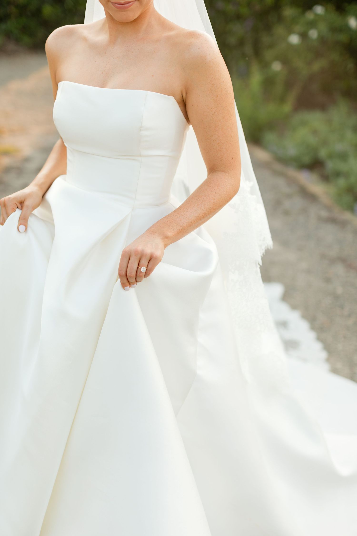 Close-up details of a strapless white wedding dress with flowing fabric and elegant draping shown in multiple angles.