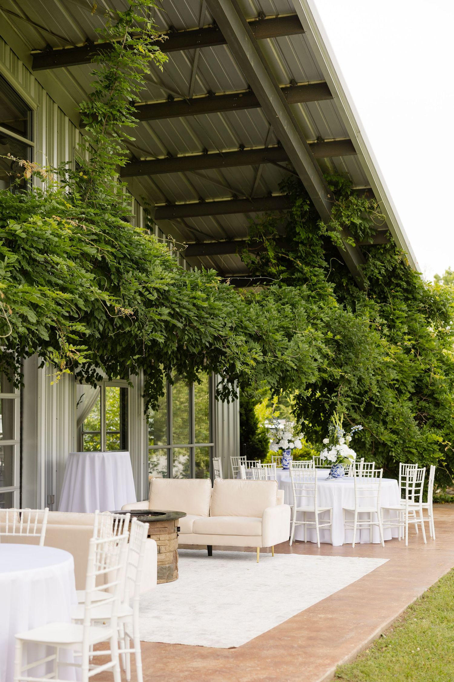 Outdoor wedding venue with white chairs and greenery-covered pergola. Cold Springs Events