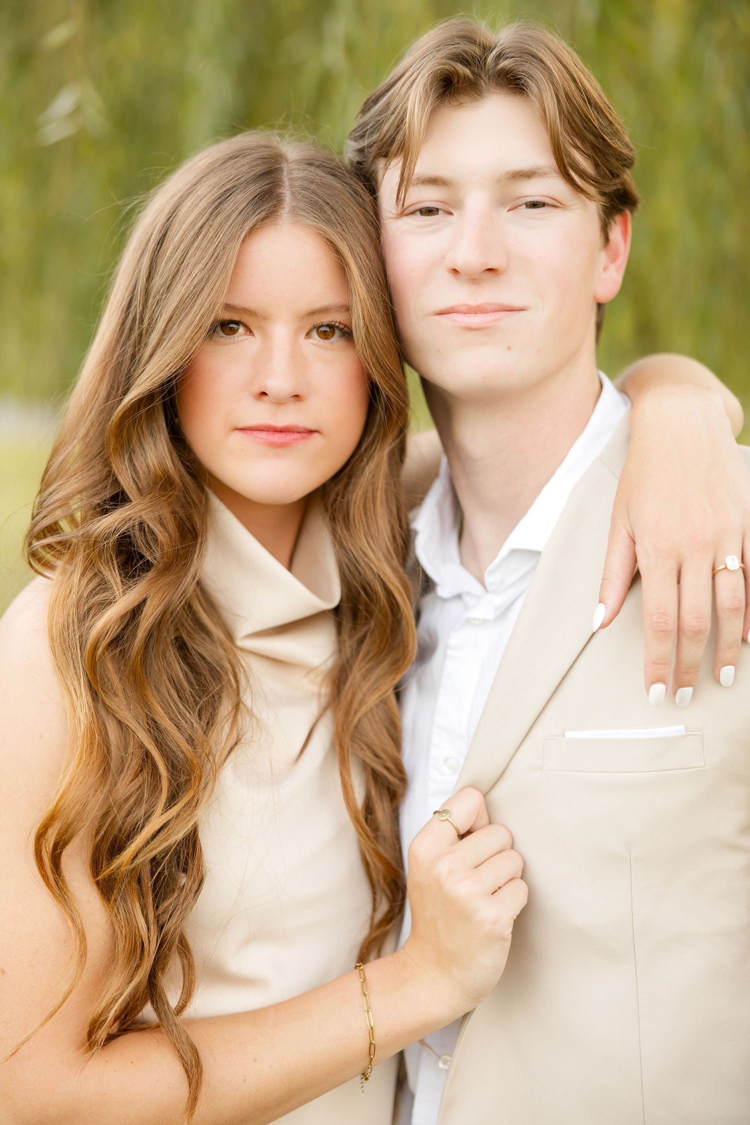 A romantic couple in light colored outfits pose together in a series of intimate close-up portraits.