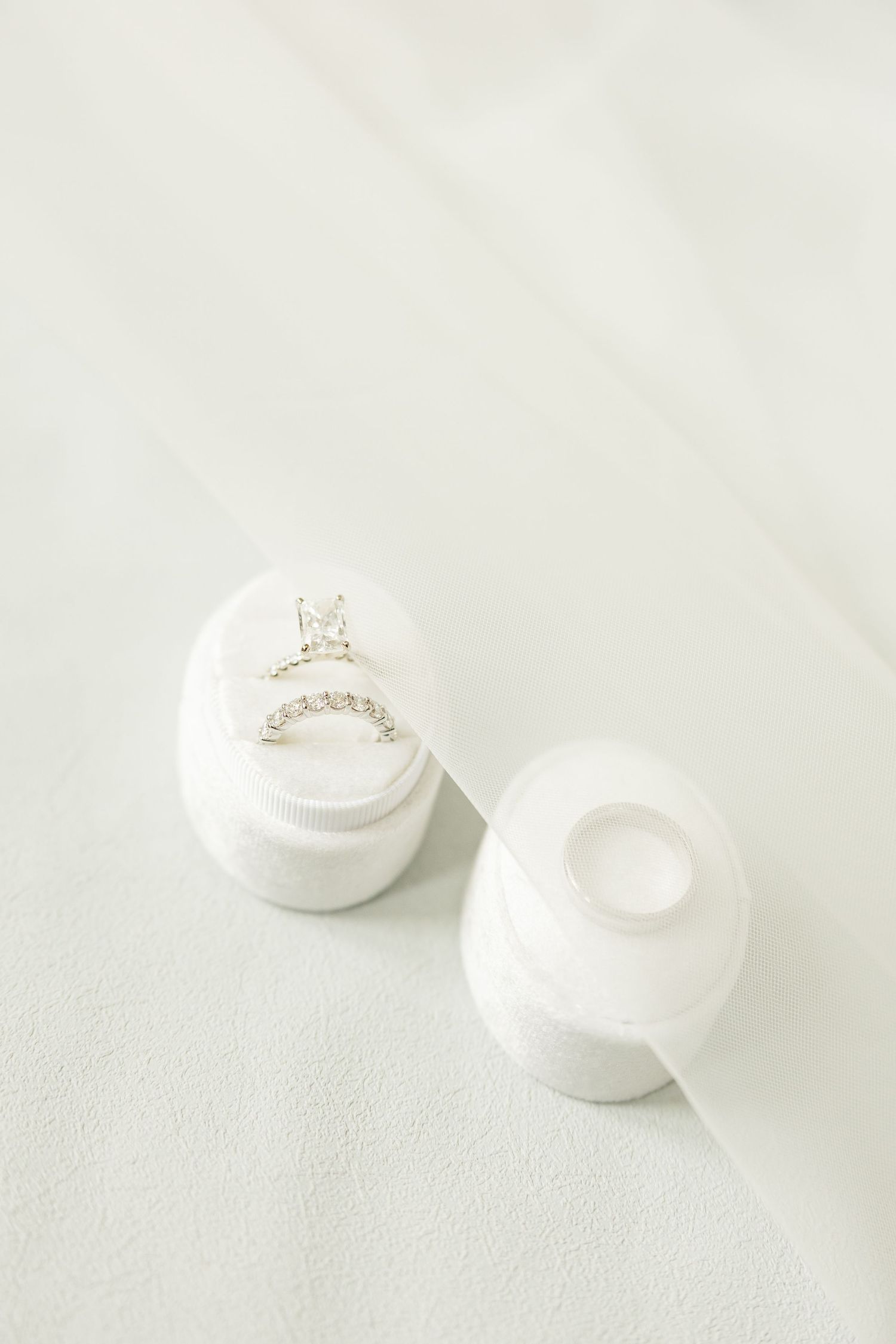 White engagement ring in a minimalist jewelry box photographed against a light background.