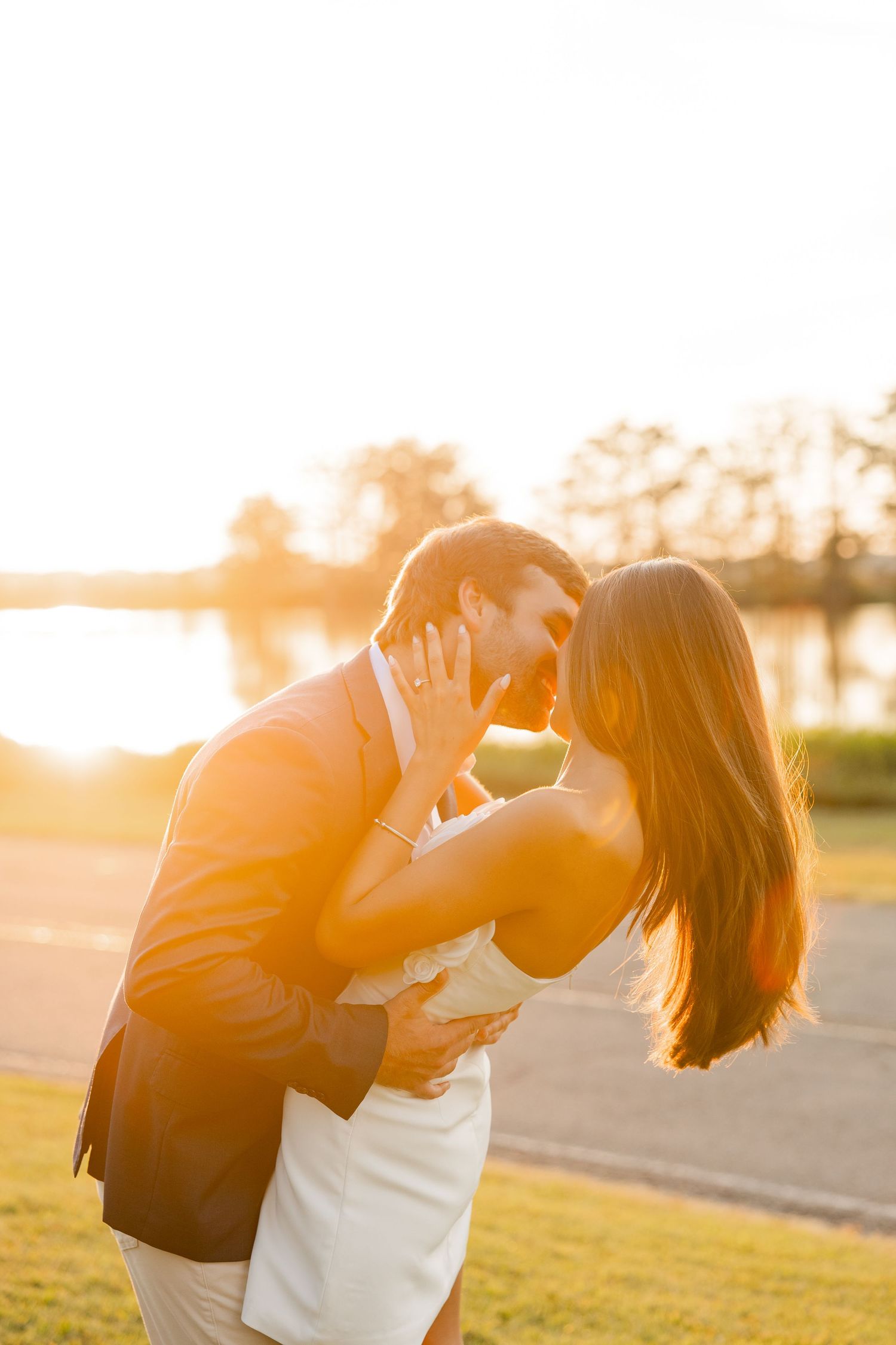 Romantic sunset photoshoot of couple embracing in golden hour light.