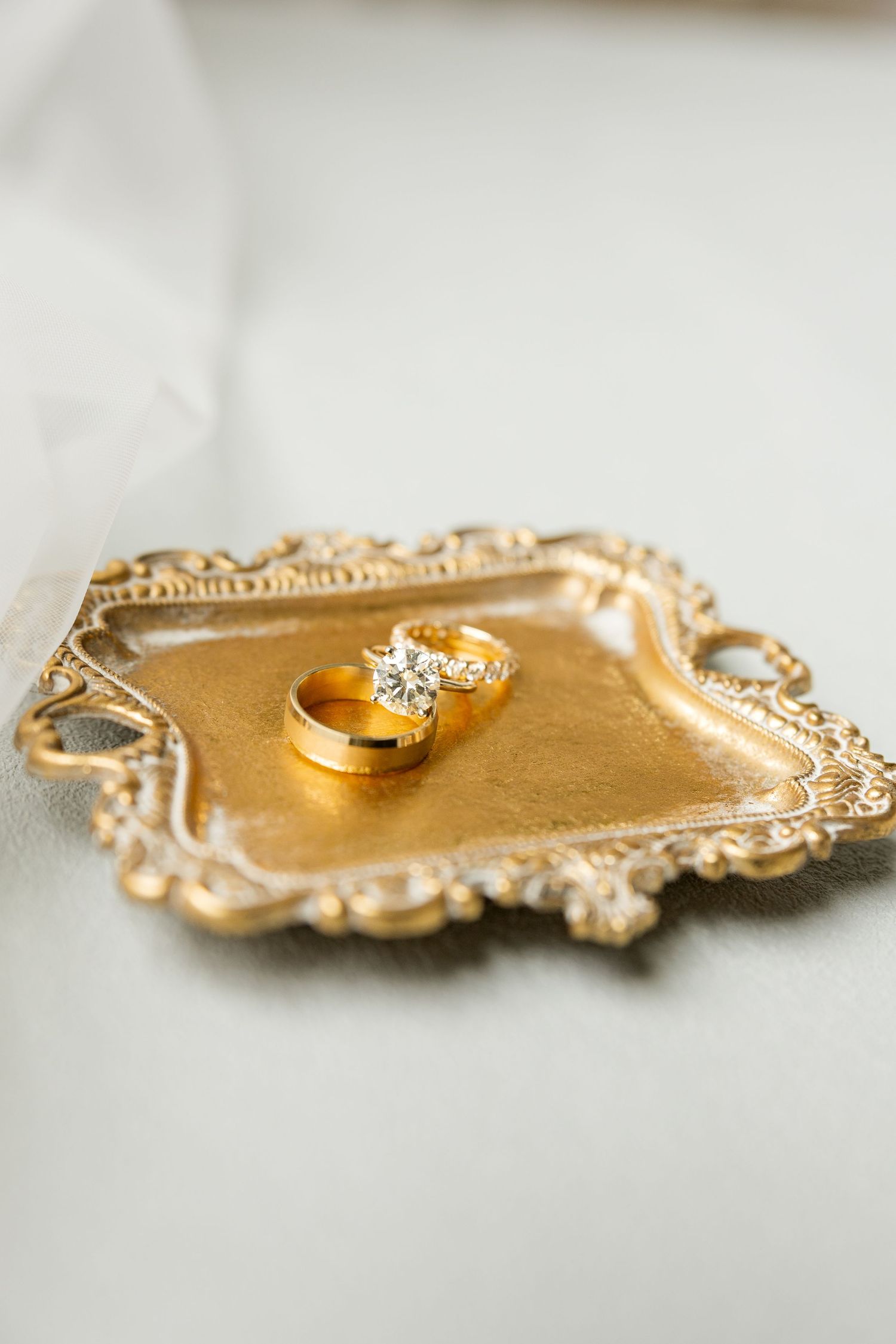 Wedding rings displayed on an ornate gold vintage tray with intricate details.Cold Springs Events