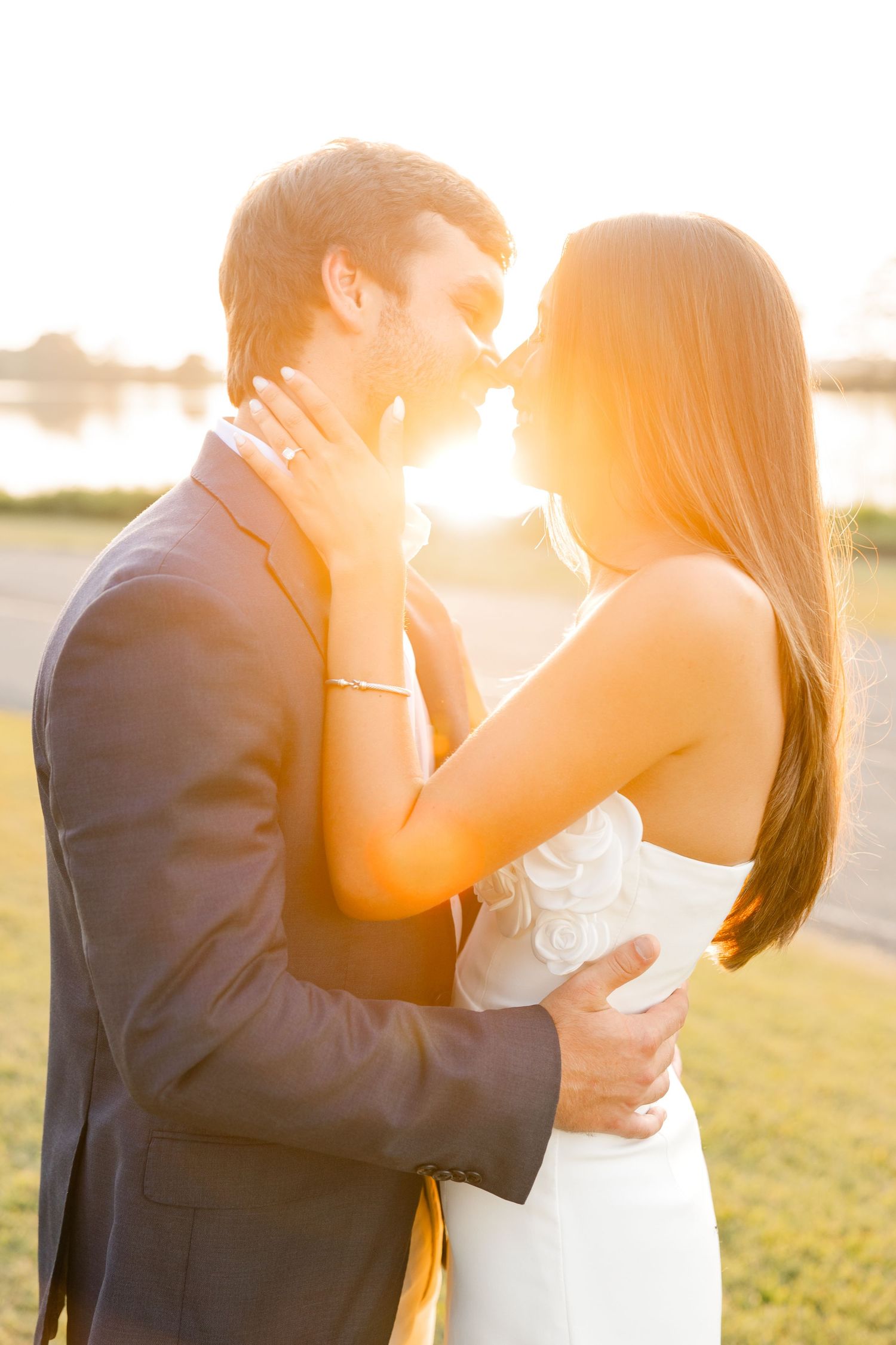 Golden sunset silhouettes couple sharing intimate moments in an open field.