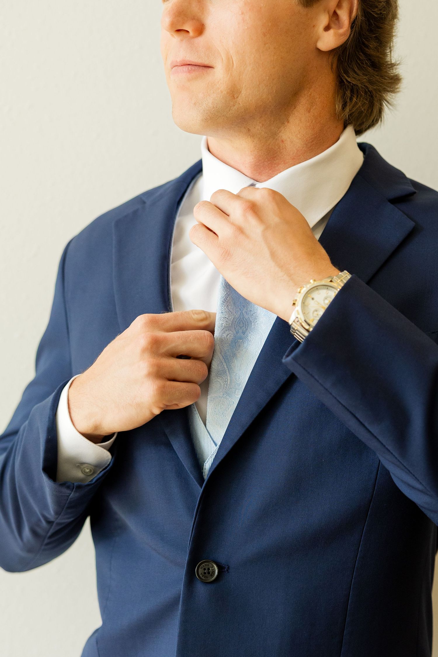Close-up shots of navy suit and light blue tie adjustments before the ceremony.Cold Springs Events.