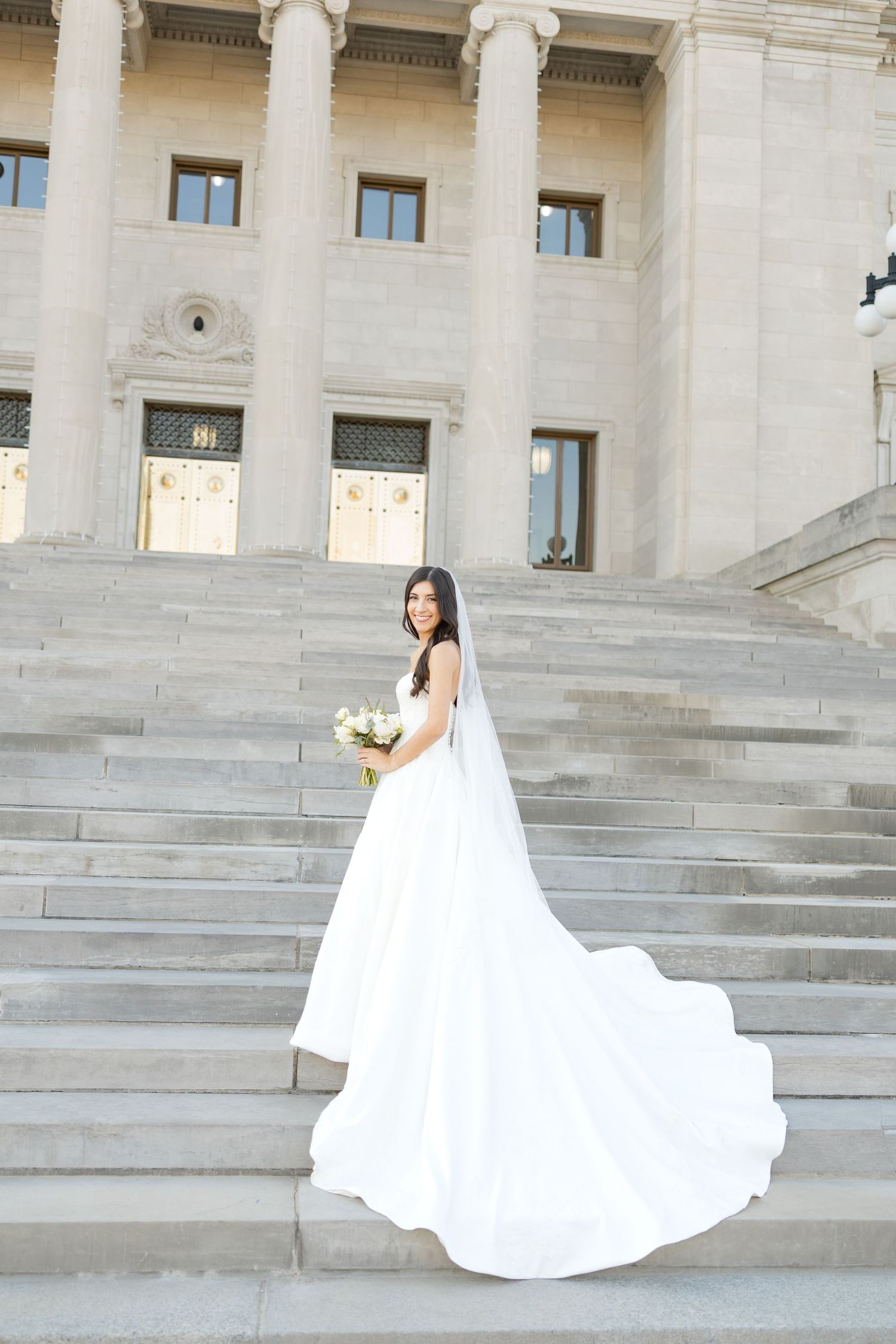 Dramatic bridal session at a neoclassical building with sweeping white stairs and columns.