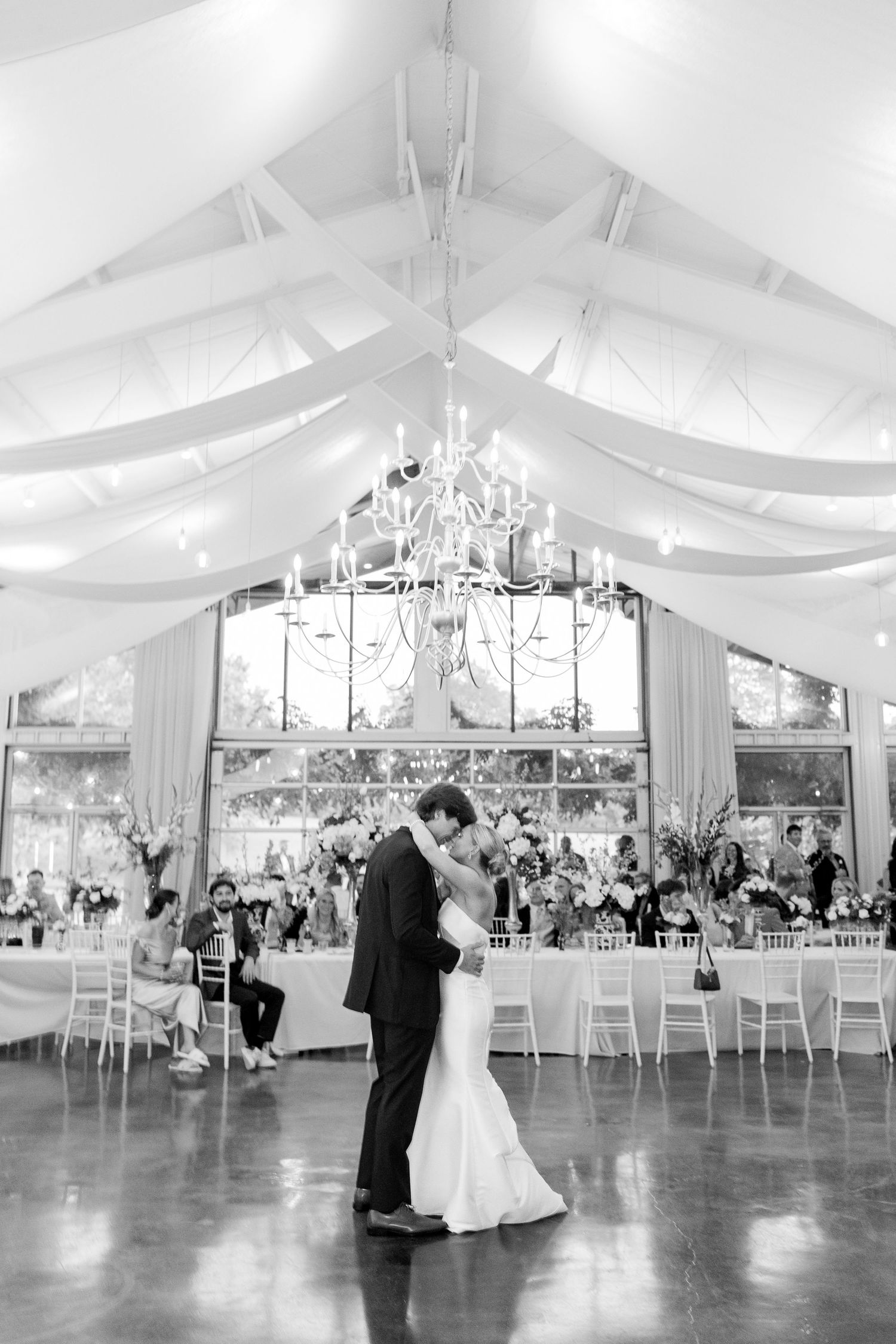 Wedding reception in a beautiful white tent venue with romantic lighting and elegant decor.Cold Springs Events