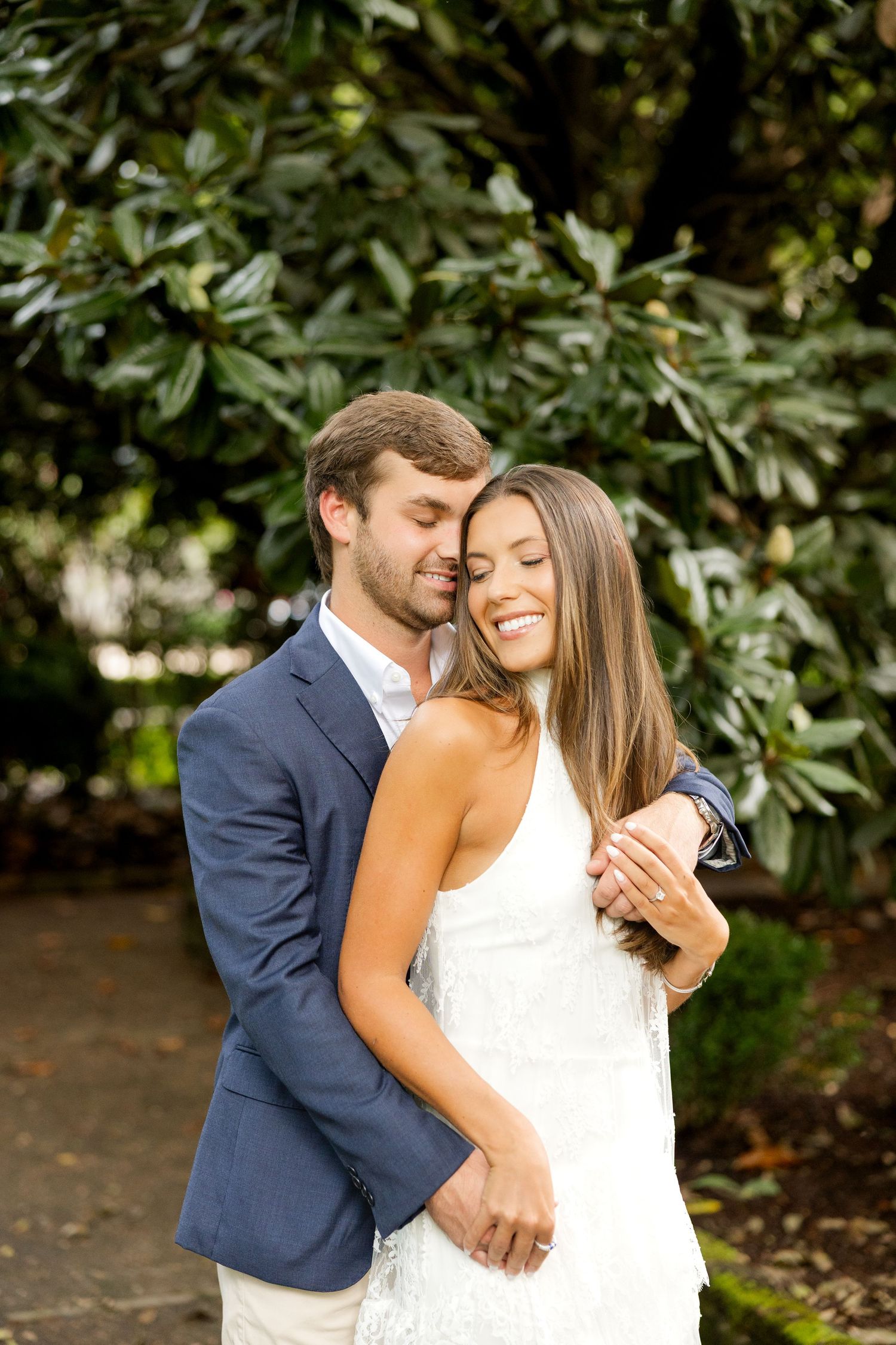 A romantic moment captured in a garden setting with a couple in wedding attire sharing joyful embraces.