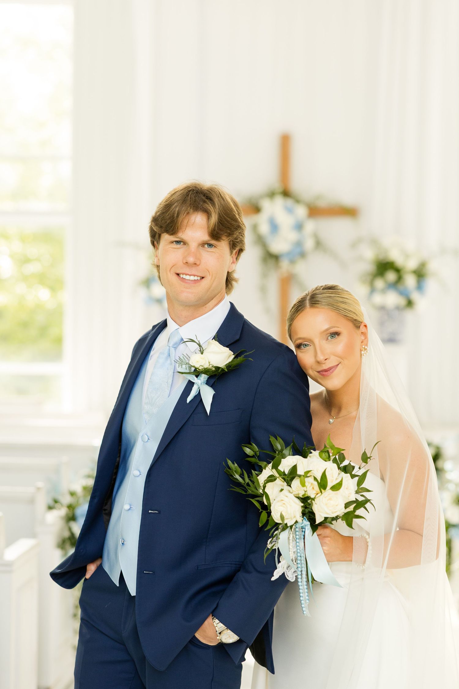Wedding couple shares intimate moments in a bright indoor venue with elegant decor.Cold Springs Events.