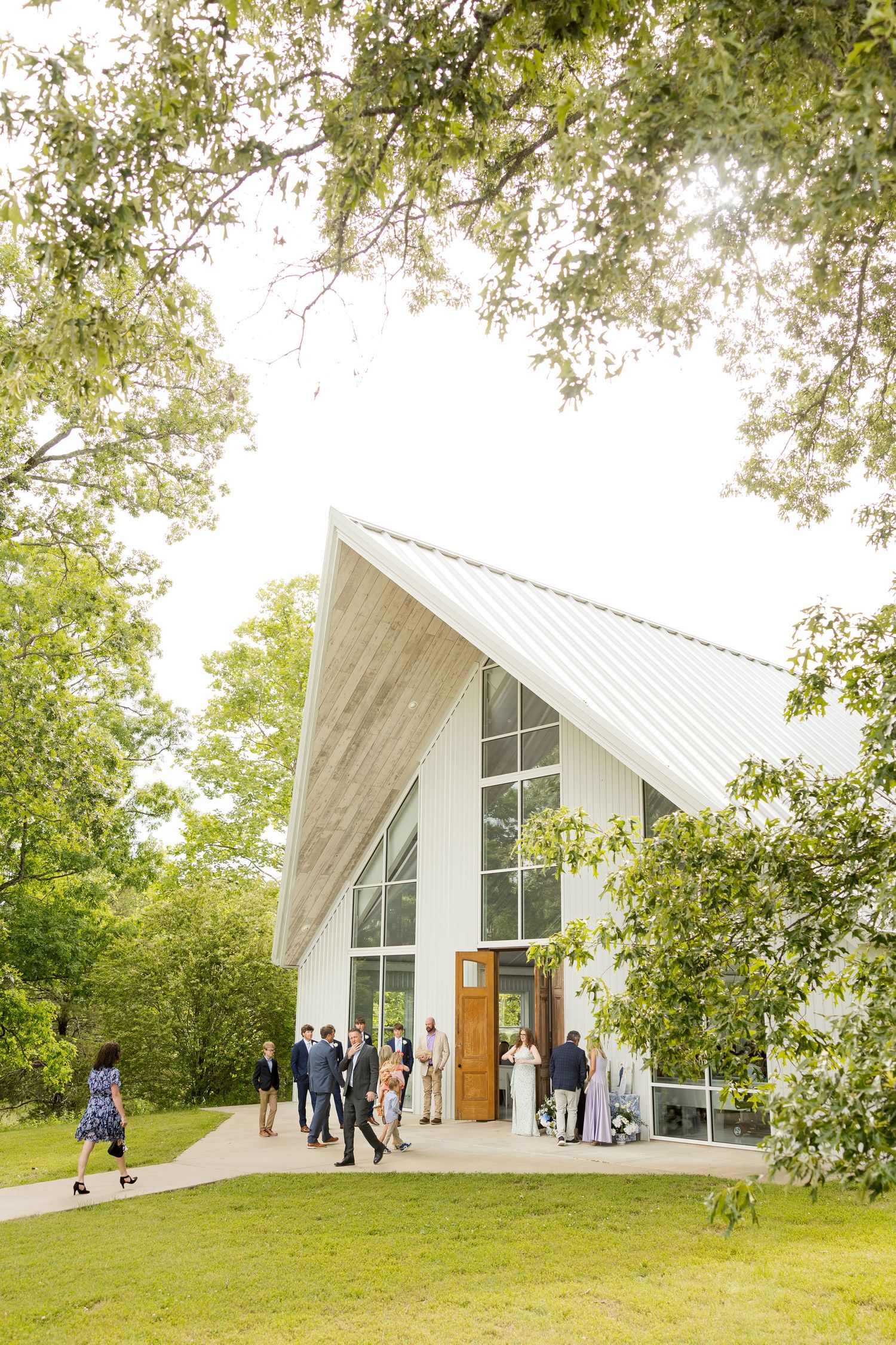 Modern white chapel wedding venue surrounded by green trees and grass.Cold Springs Events.