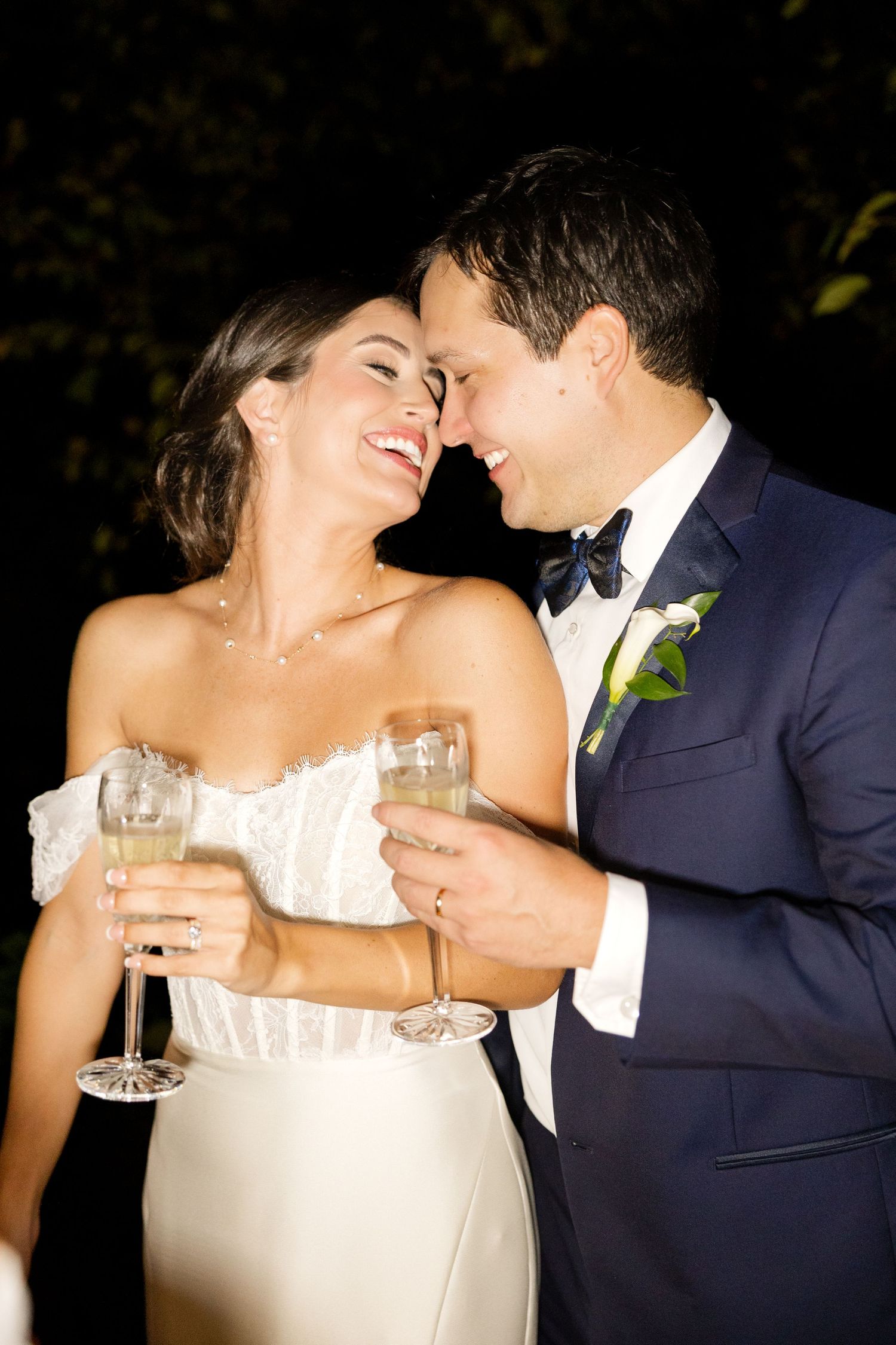Intimate moment shared between newlyweds during wedding reception toasts with champagne glasses.Botanical Gardens of the Ozarks