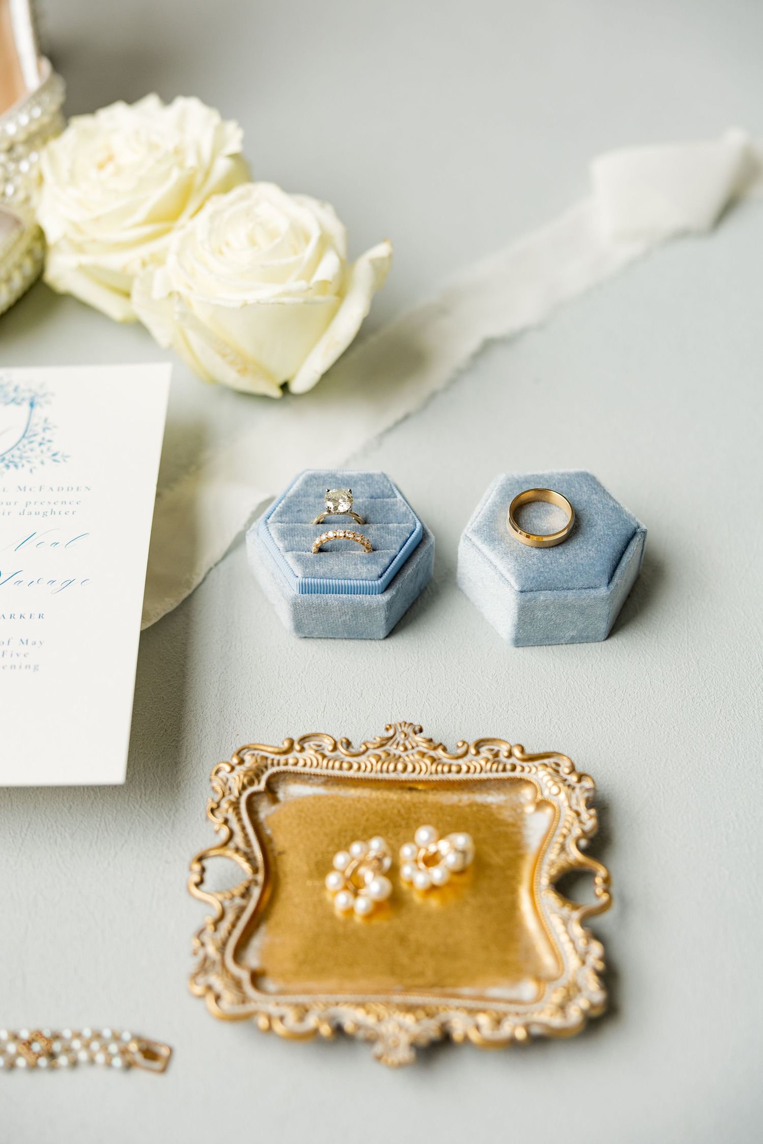 Wedding rings and stationery displayed on vintage gold trays with blue velvet ring boxes.Cold Springs Events