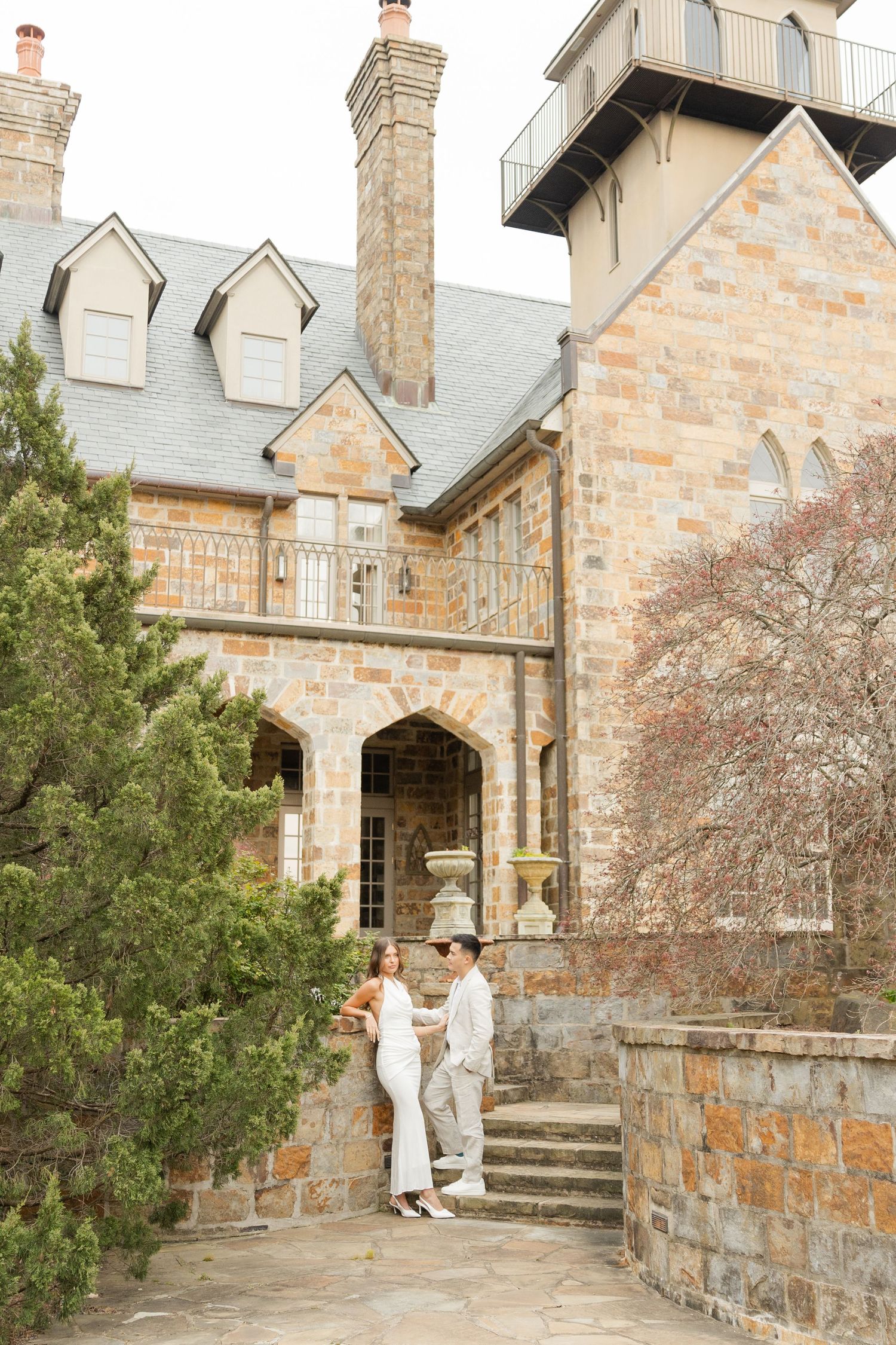 A series of photos showing a couple walking near a stone mansion with architectural details and landscaping. Goodwin Manor