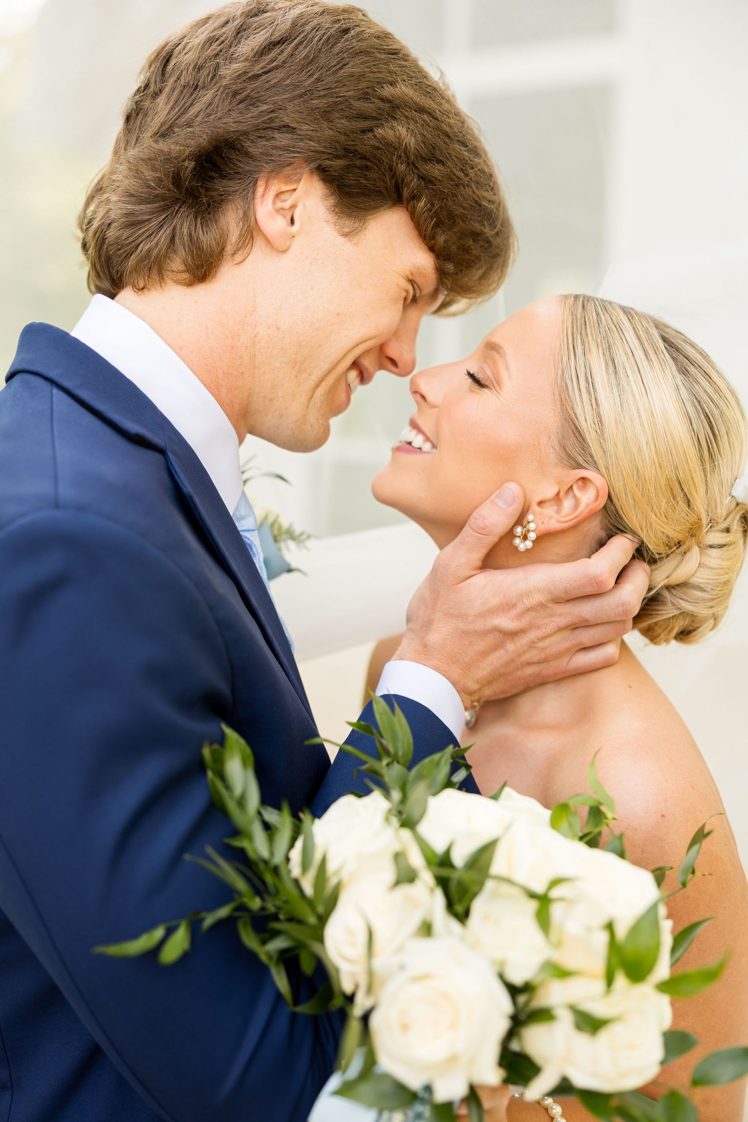 Romantic wedding moment captured with white roses and navy suit. Cold Springs Events