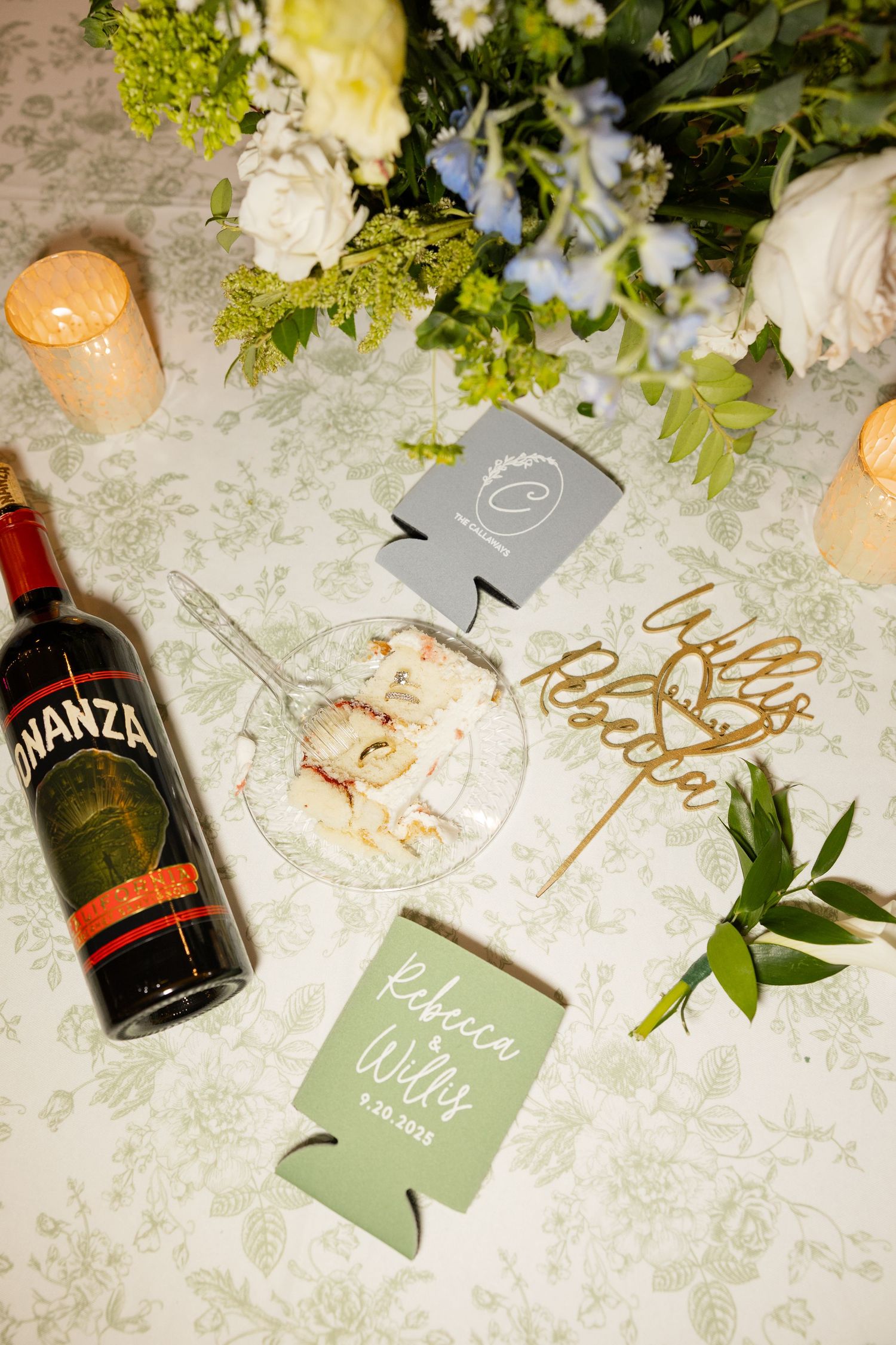 Wedding reception details with Avanza wine bottle, koozies, and floral decorations on patterned tablecloth.Botanical Gardens of the Ozarks