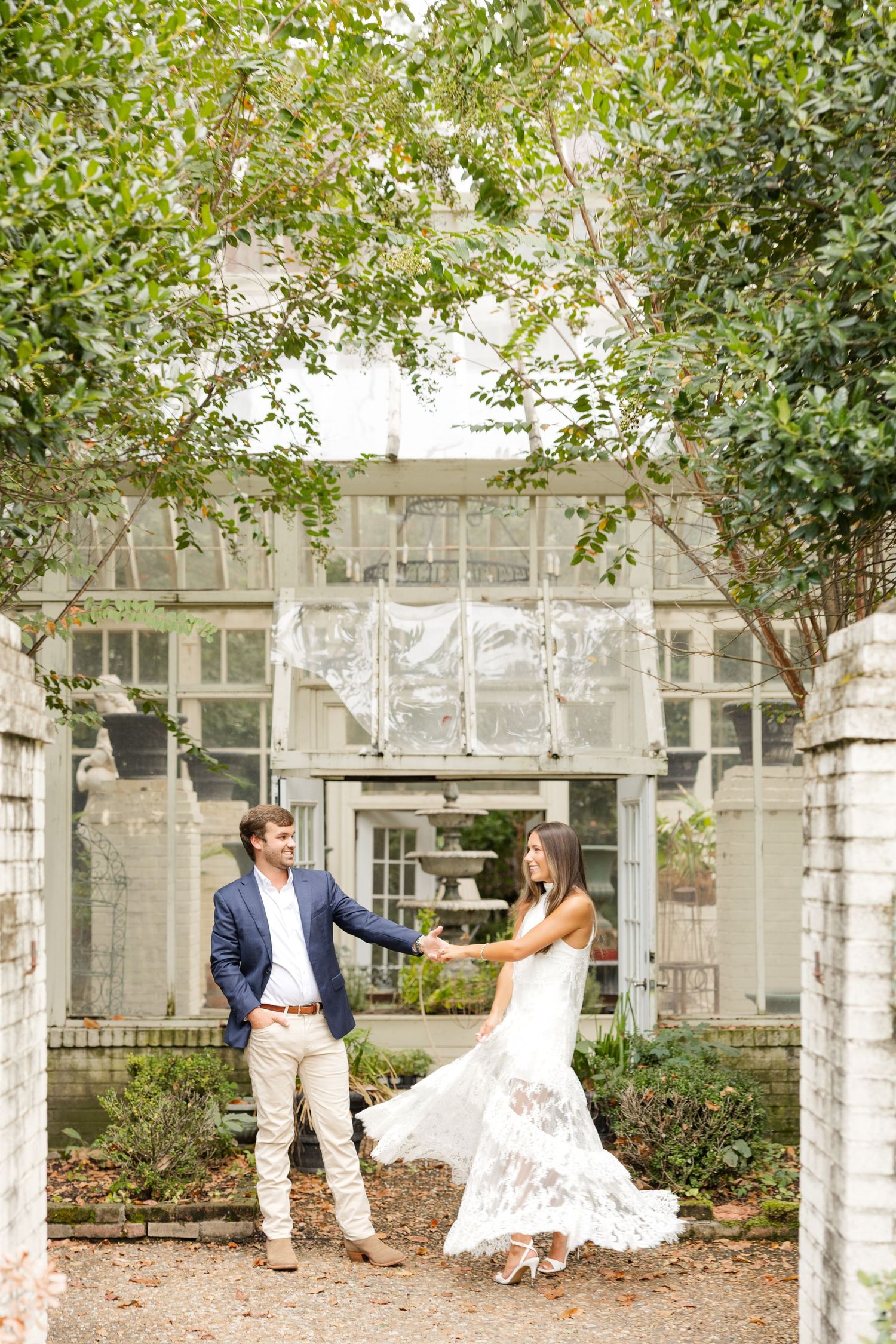 A romantic engagement photo sequence under a white columned porch with overhanging trees and greenery.