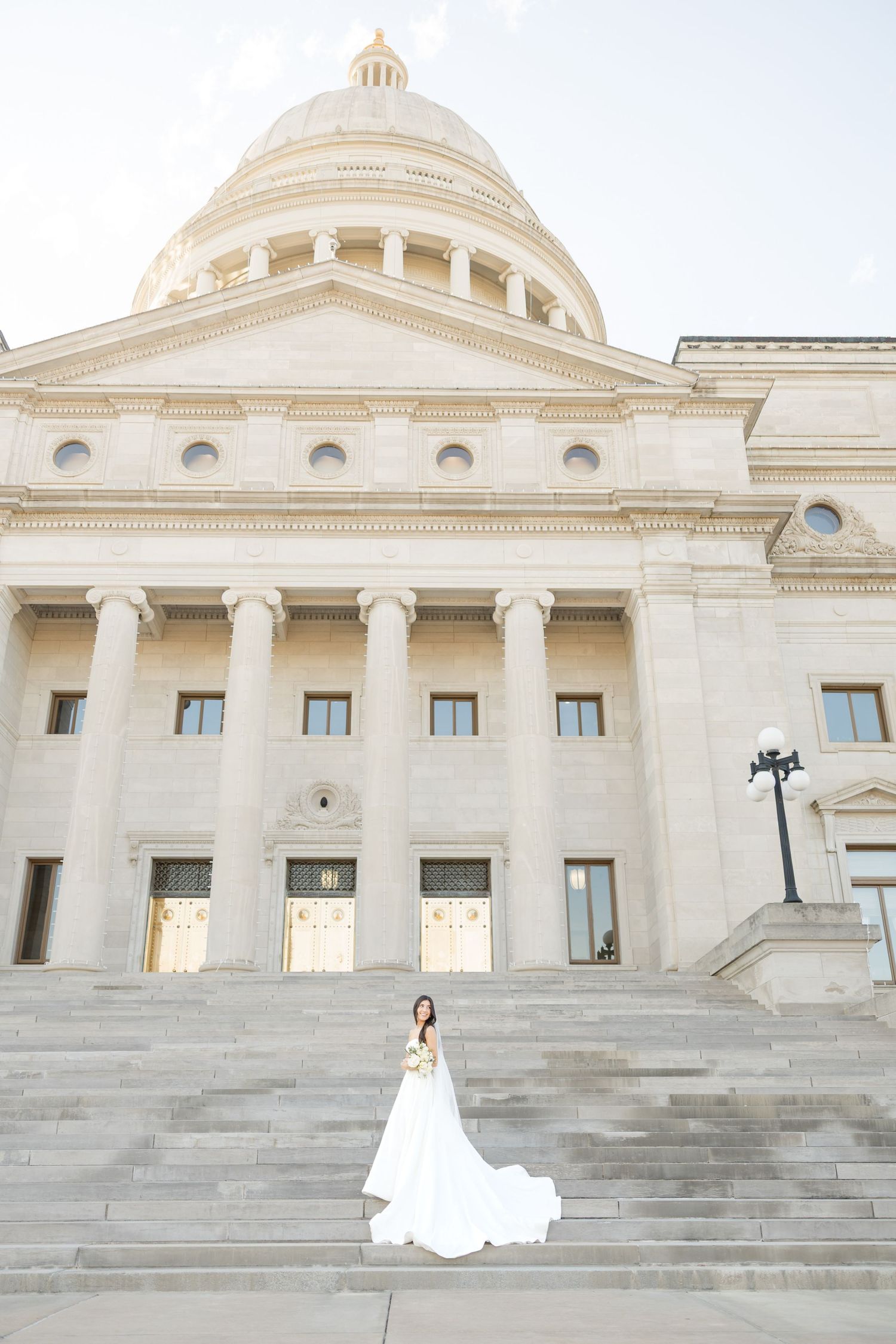 Wedding photos captured at the Arkansas State Capitol featuring grand architecture and dome.