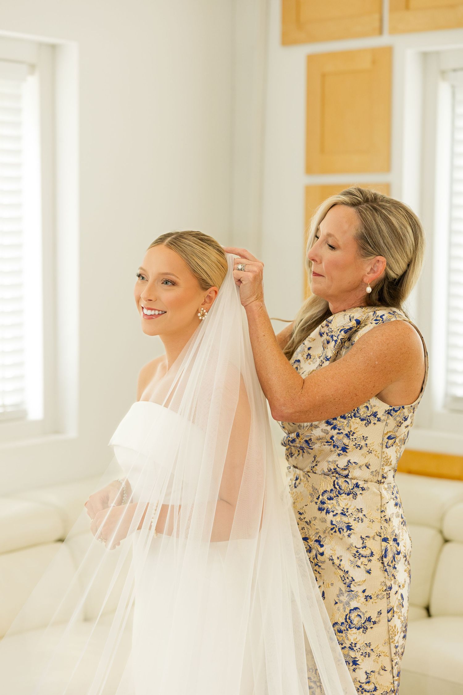 Final wedding dress adjustments being made in bright room with white and beige decor.Cold Springs Events