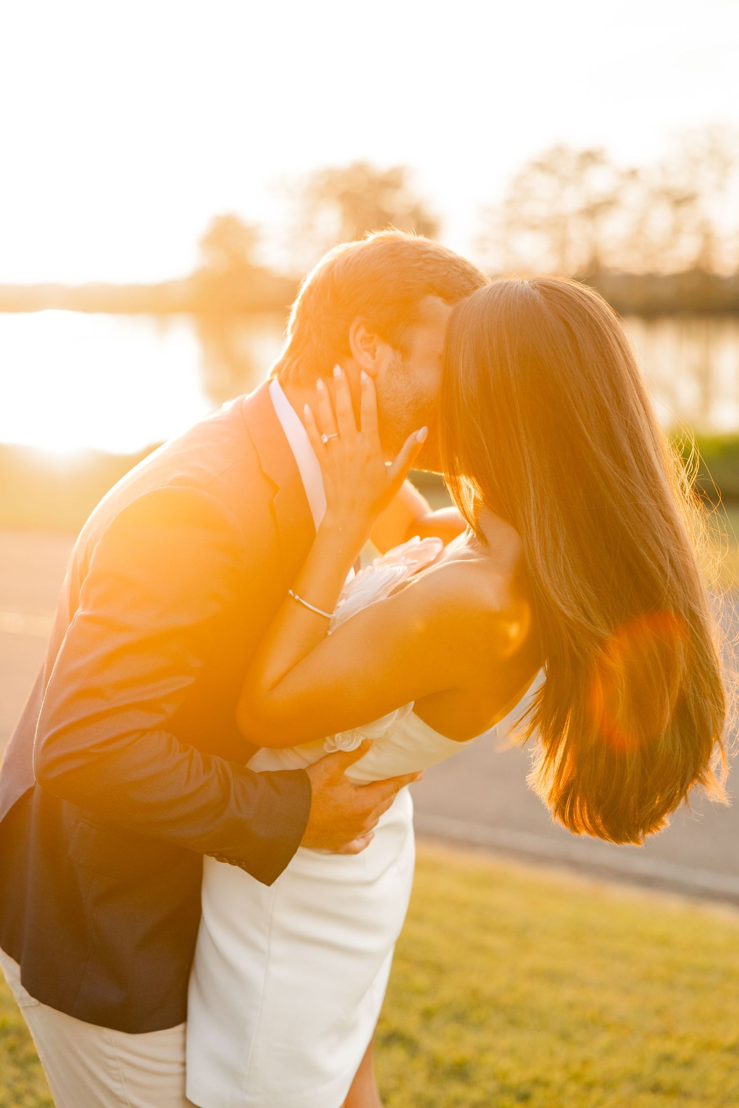 Romantic silhouettes embracing against a warm golden sunset backdrop.