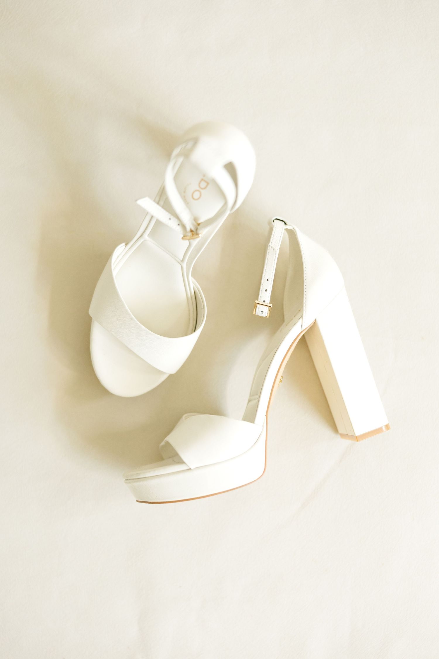 White high heel platform wedding shoes photographed from different angles on a light background. Cold Springs Events