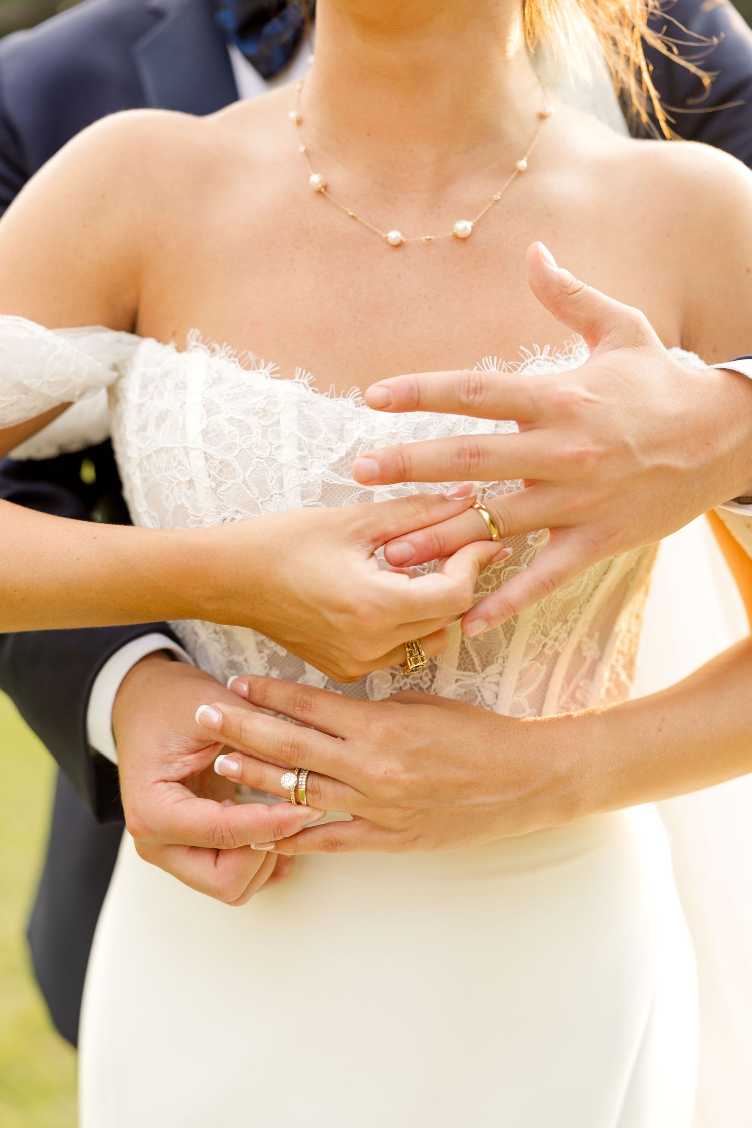 Close-up of wedding rings and jewelry with lace dress details in natural light. Botanical Gardens of the Ozarks