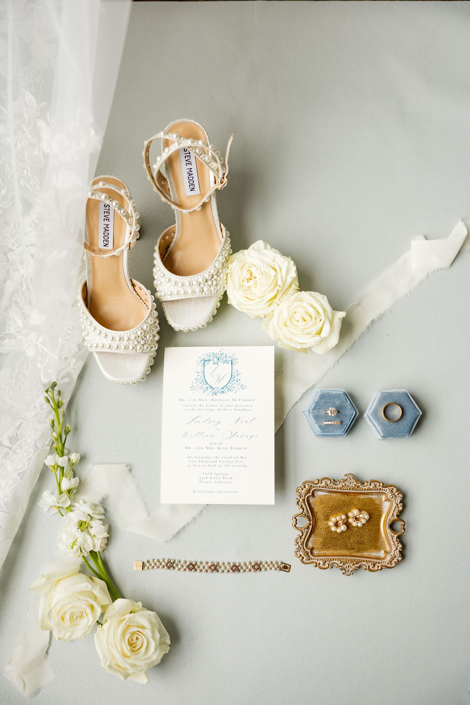 Wedding flat lay with white roses, bridal shoes and invitation suite on grey background.Cold Springs Events.