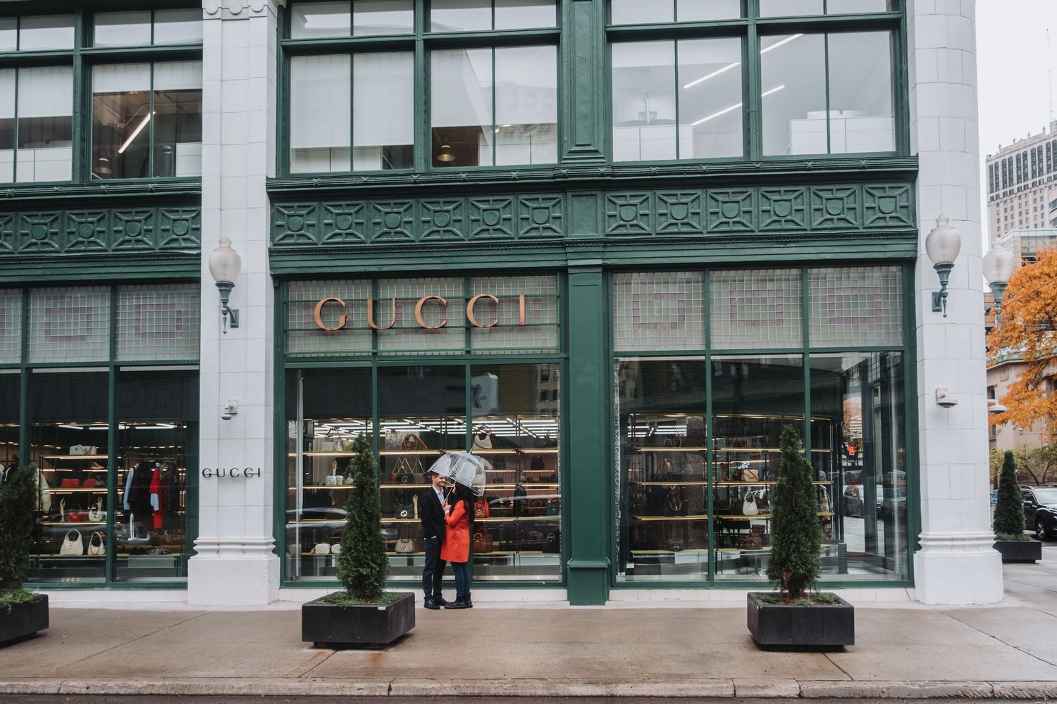 Urban storefront with green trim and large glass windows along a commercial street.