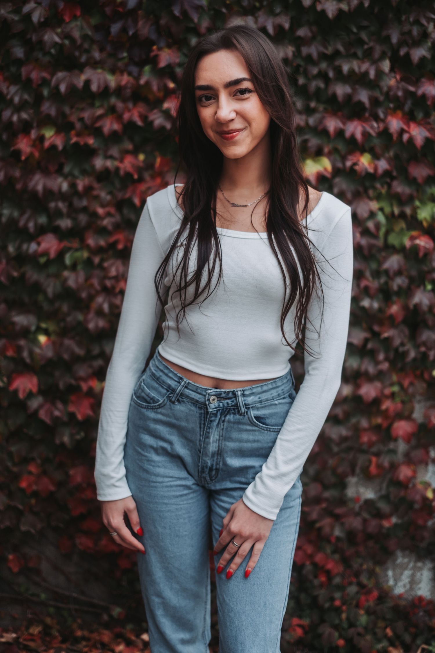 Fashion photo series showing casual outfit with white crop top and light blue jeans against autumn foliage.