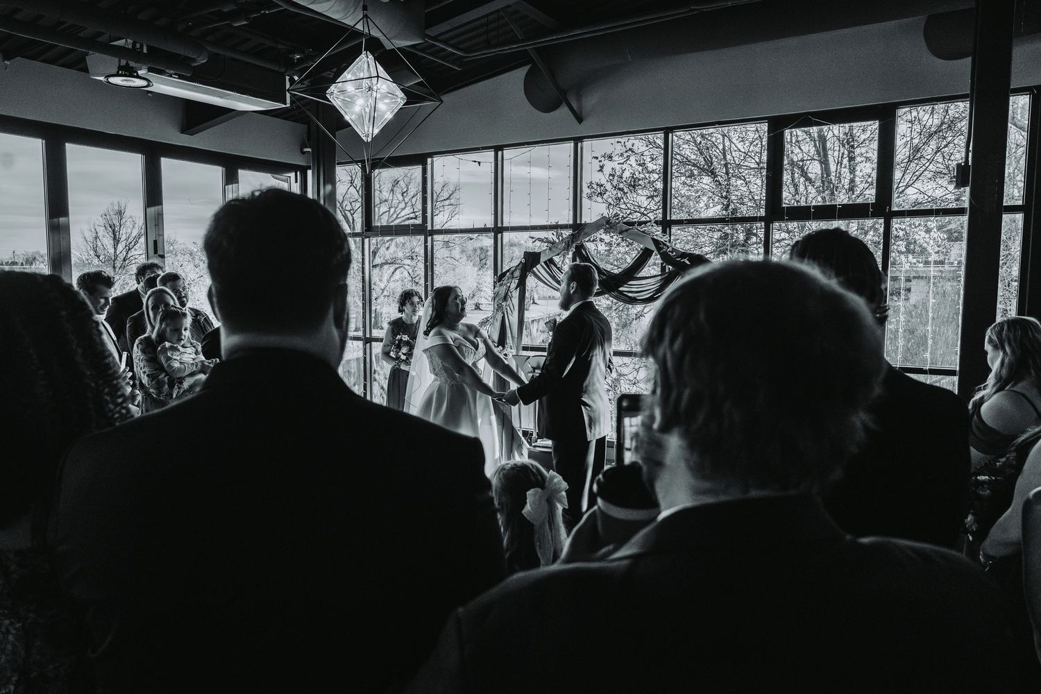 Wedding guests gather in an indoor venue for a celebration event.
