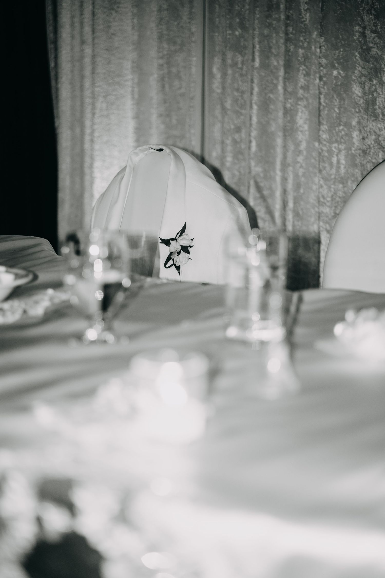 Black and white photo of an elegant wedding reception table with silver candlesticks and a floral place card.