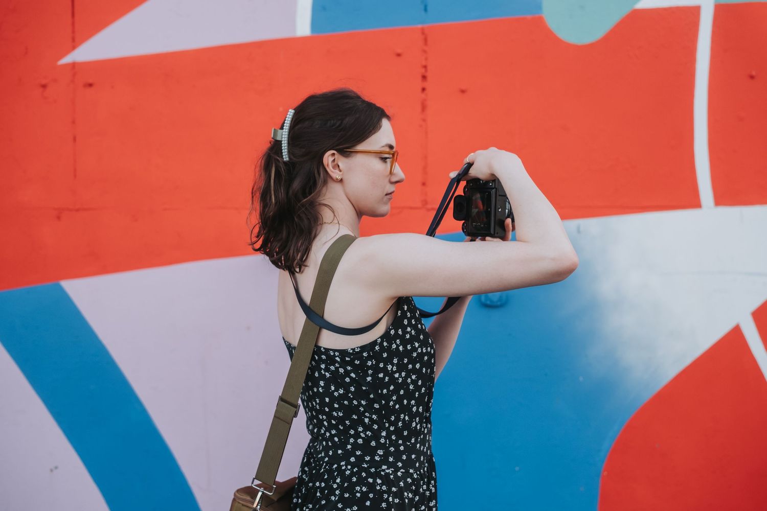 Abstract geometric mural with bright red, blue and white shapes against a wall.