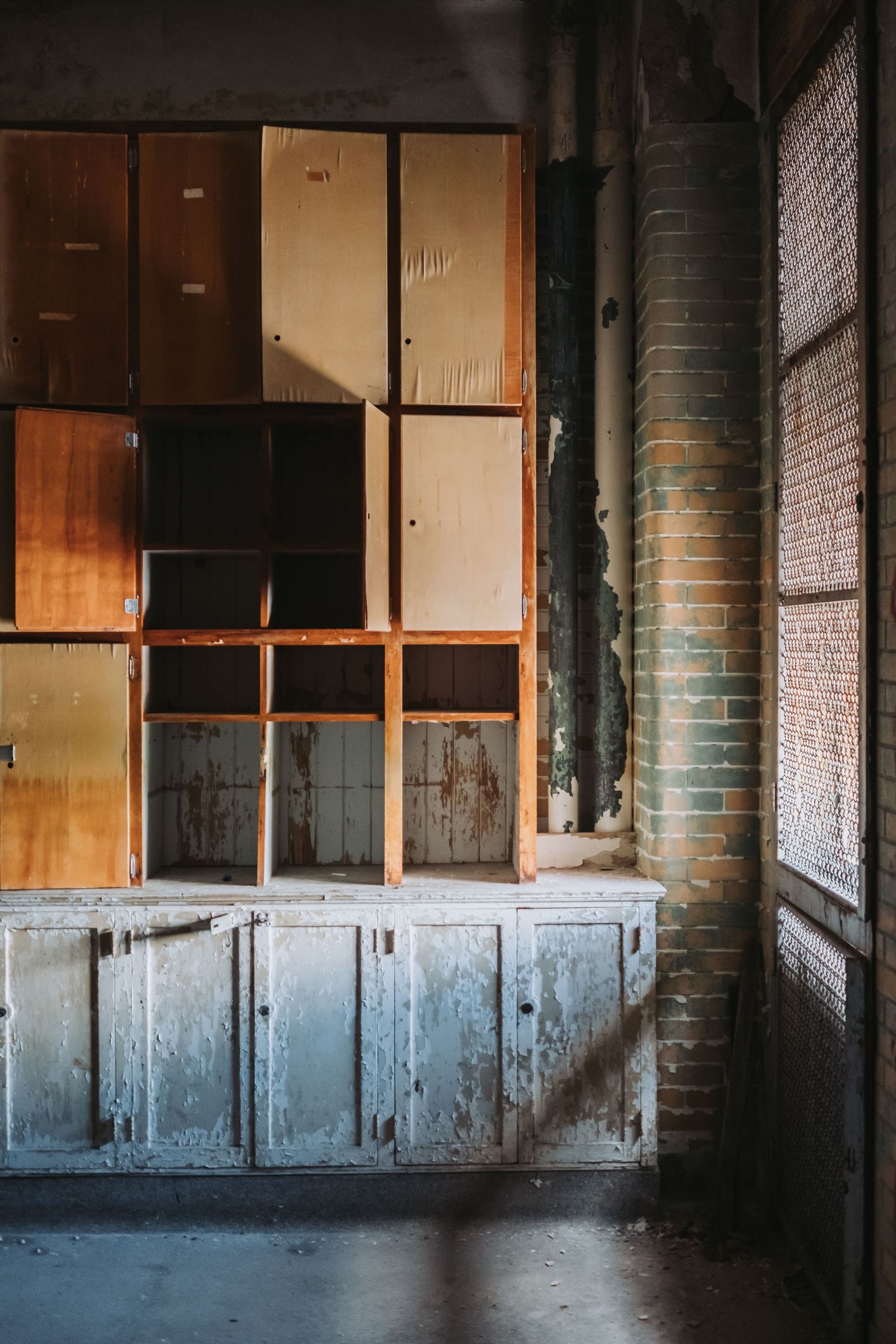 Abandoned industrial interior with worn blue walls and empty window frames.