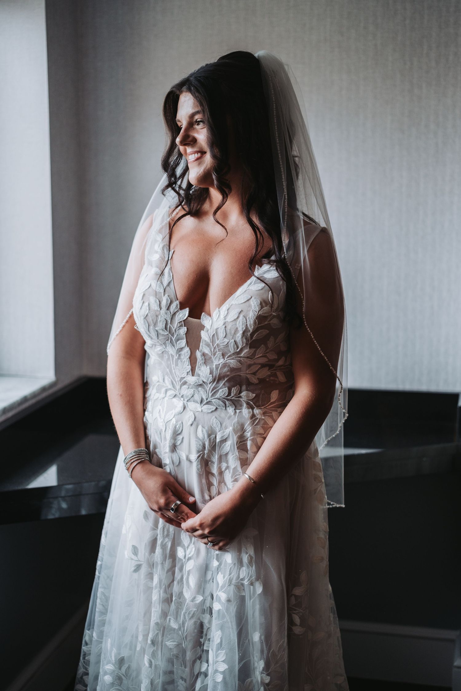 Close-up details of an intricate white lace wedding dress with delicate embellishments.