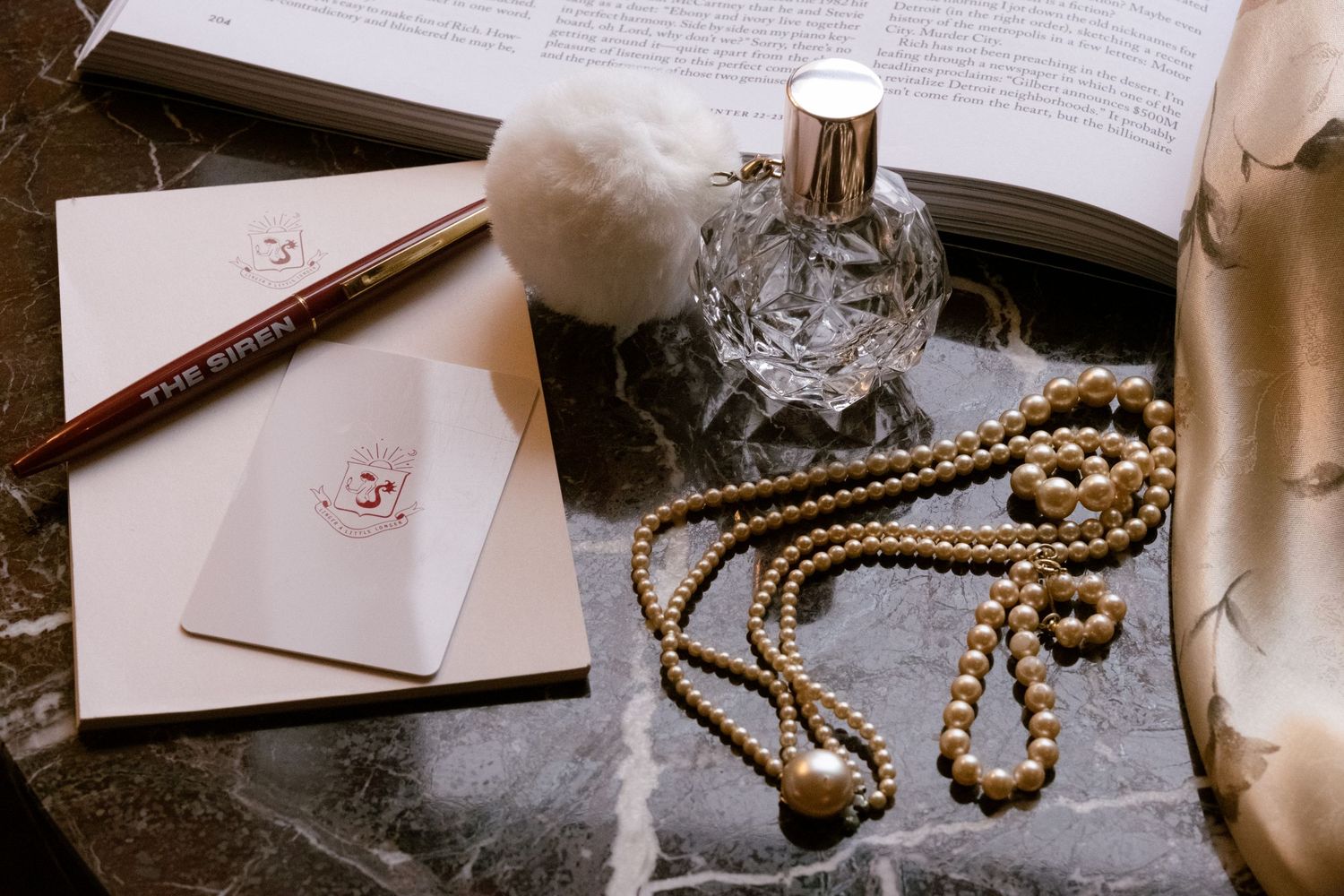 Vintage wedding details including jewelry, paper, and decorative elements arranged on a table.