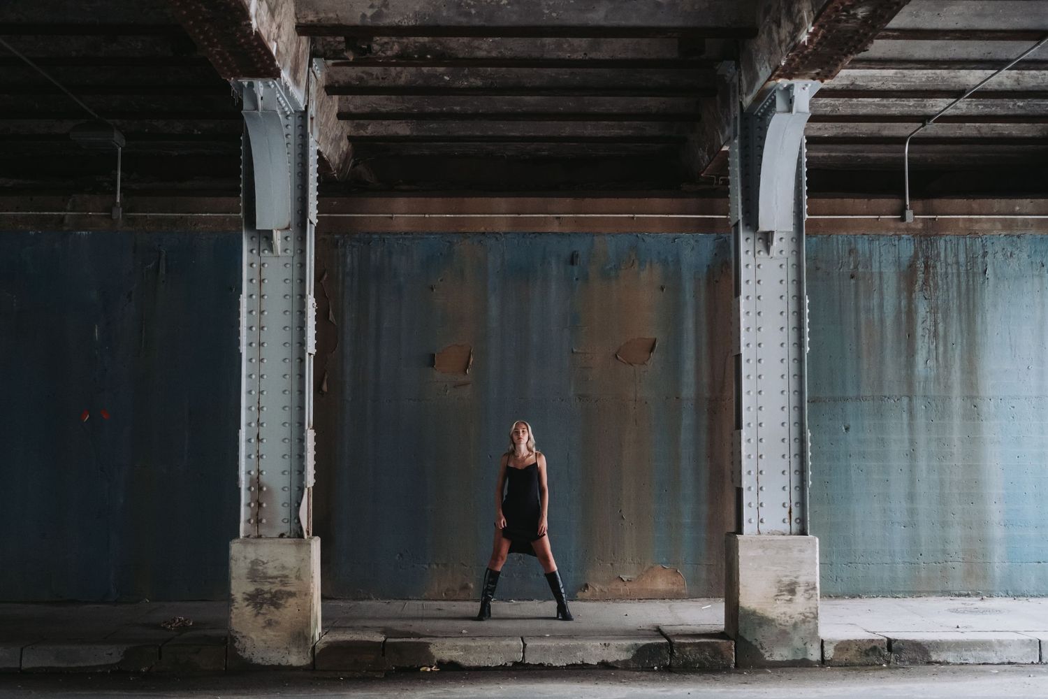 Dark industrial interior with columns and windows.