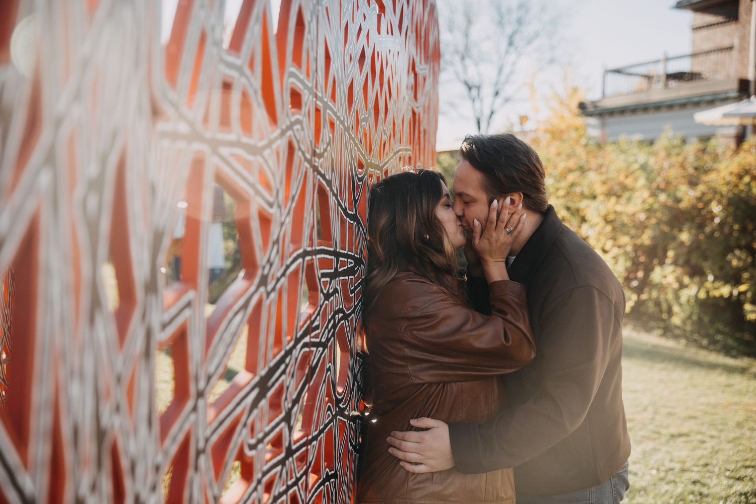 Couple embraces against graffiti wall in romantic outdoor photoshoot during autumn season.