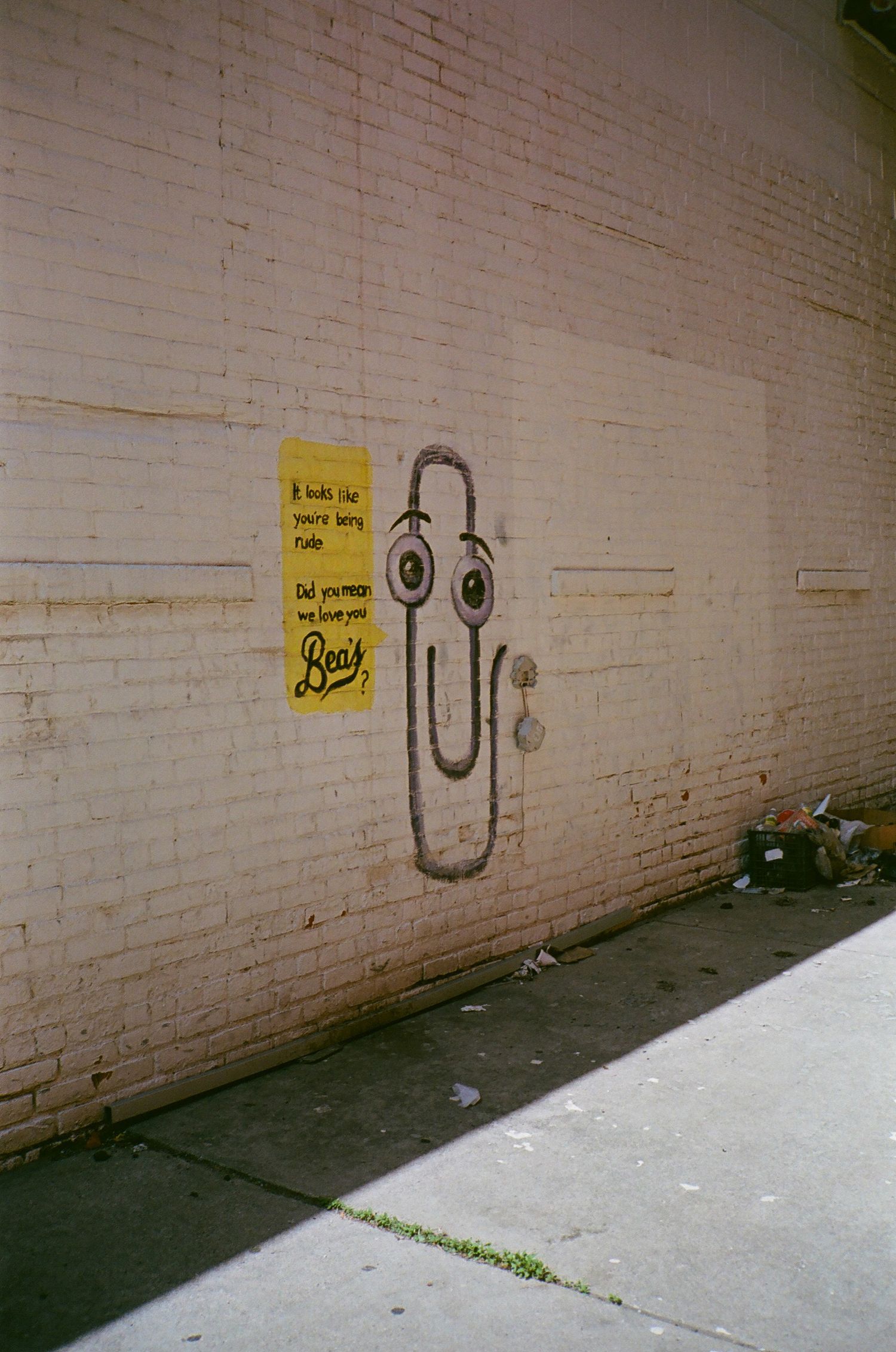 Simple graffiti art progression showing a smiley face being drawn on a white brick wall.