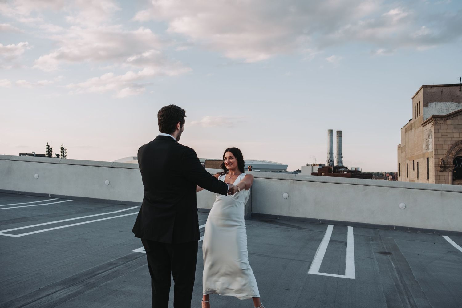 Rooftop wedding photos with city skyline and parking lot markings visible.