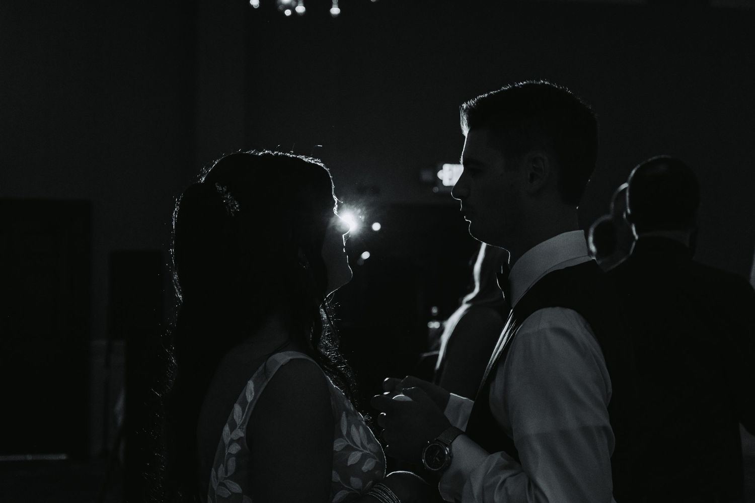 Dark silhouettes of people dancing at a nighttime celebration or party.
