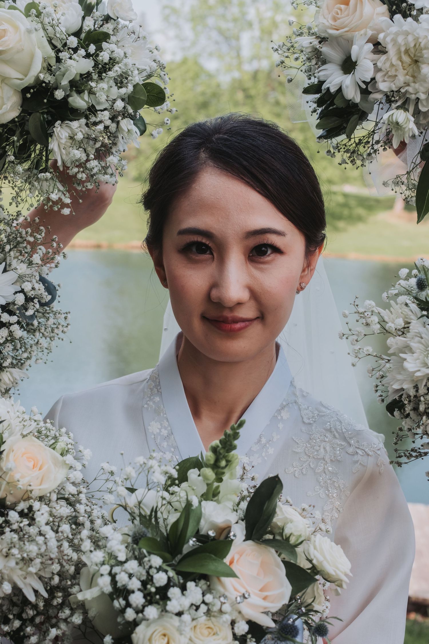 Bridal portrait surrounded by delicate white and pink floral arrangements.