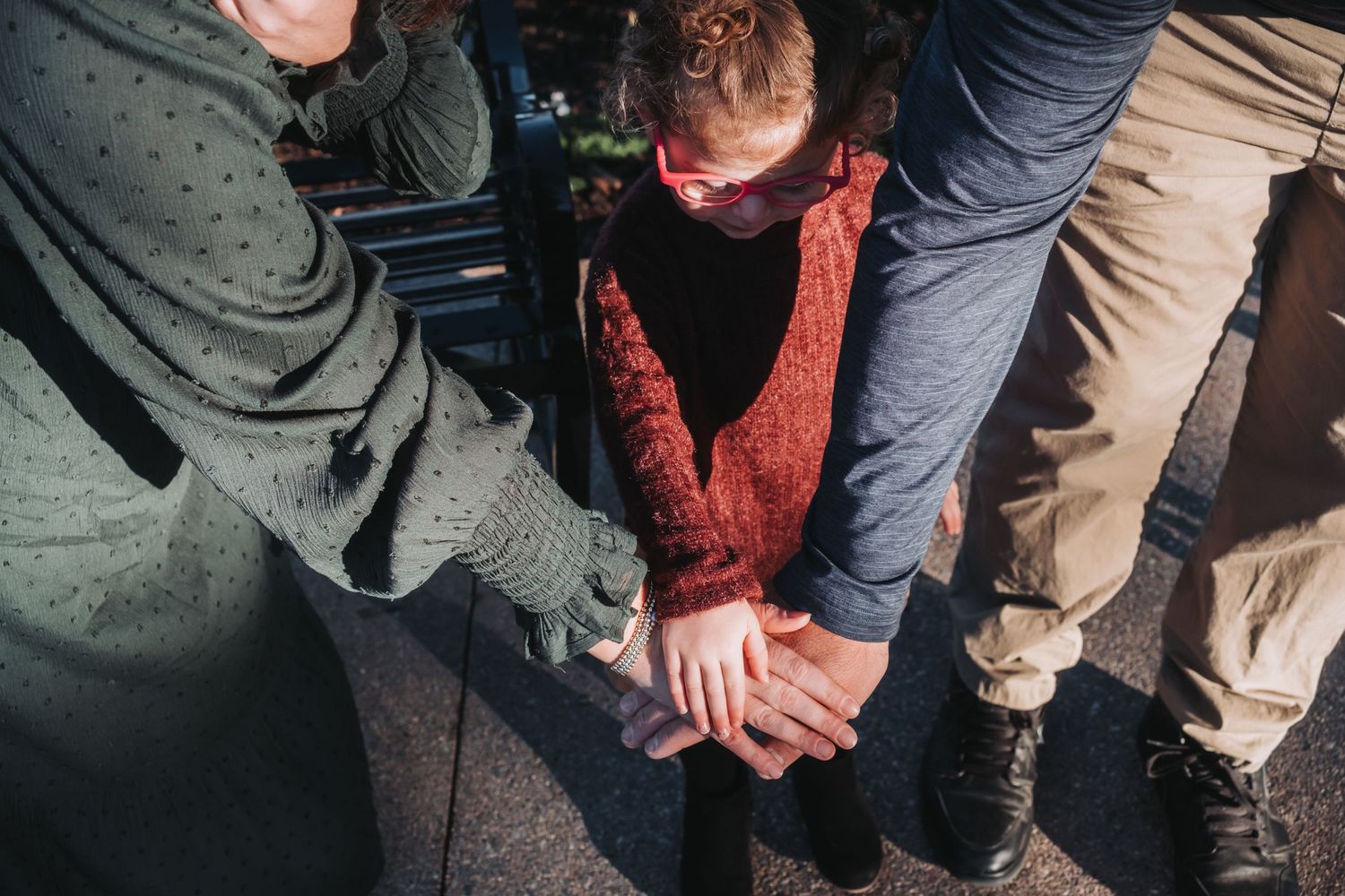 Close-up view of people's legs and feet gathered in a casual outdoor setting.