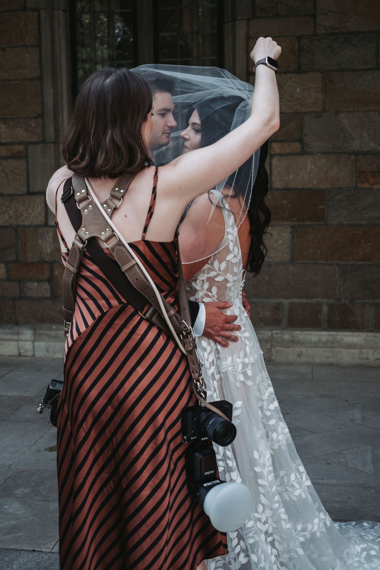 Wedding photography session with people in formal attire posing outdoors.
