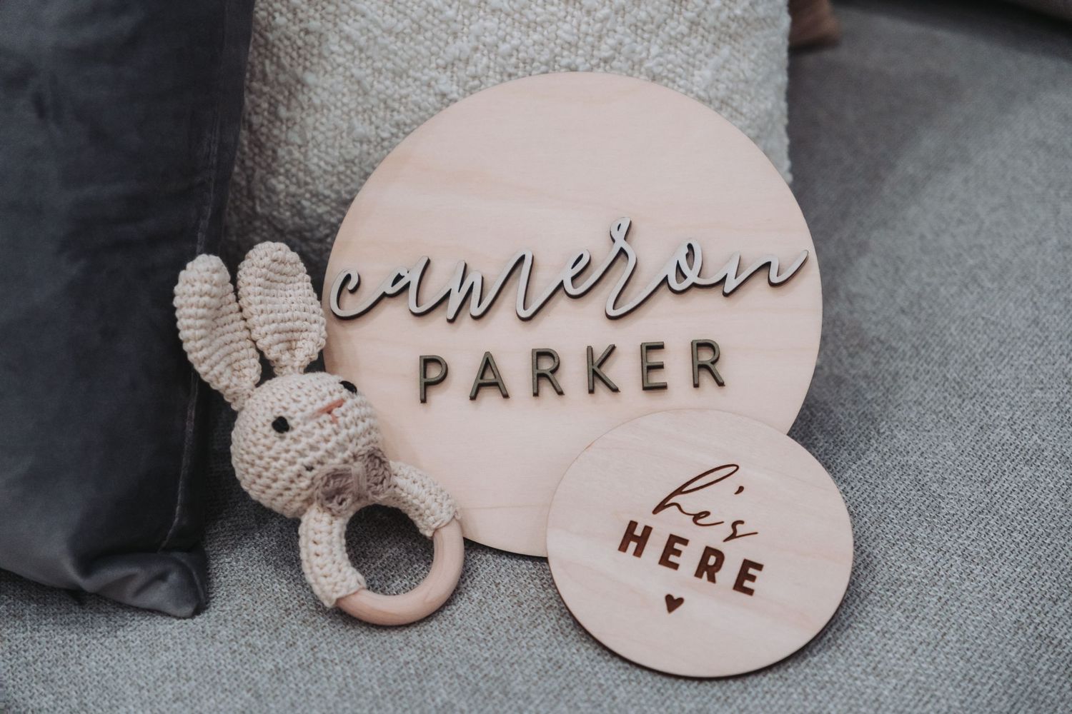 Wooden decorative signs with text carved into them are displayed on a gray surface.