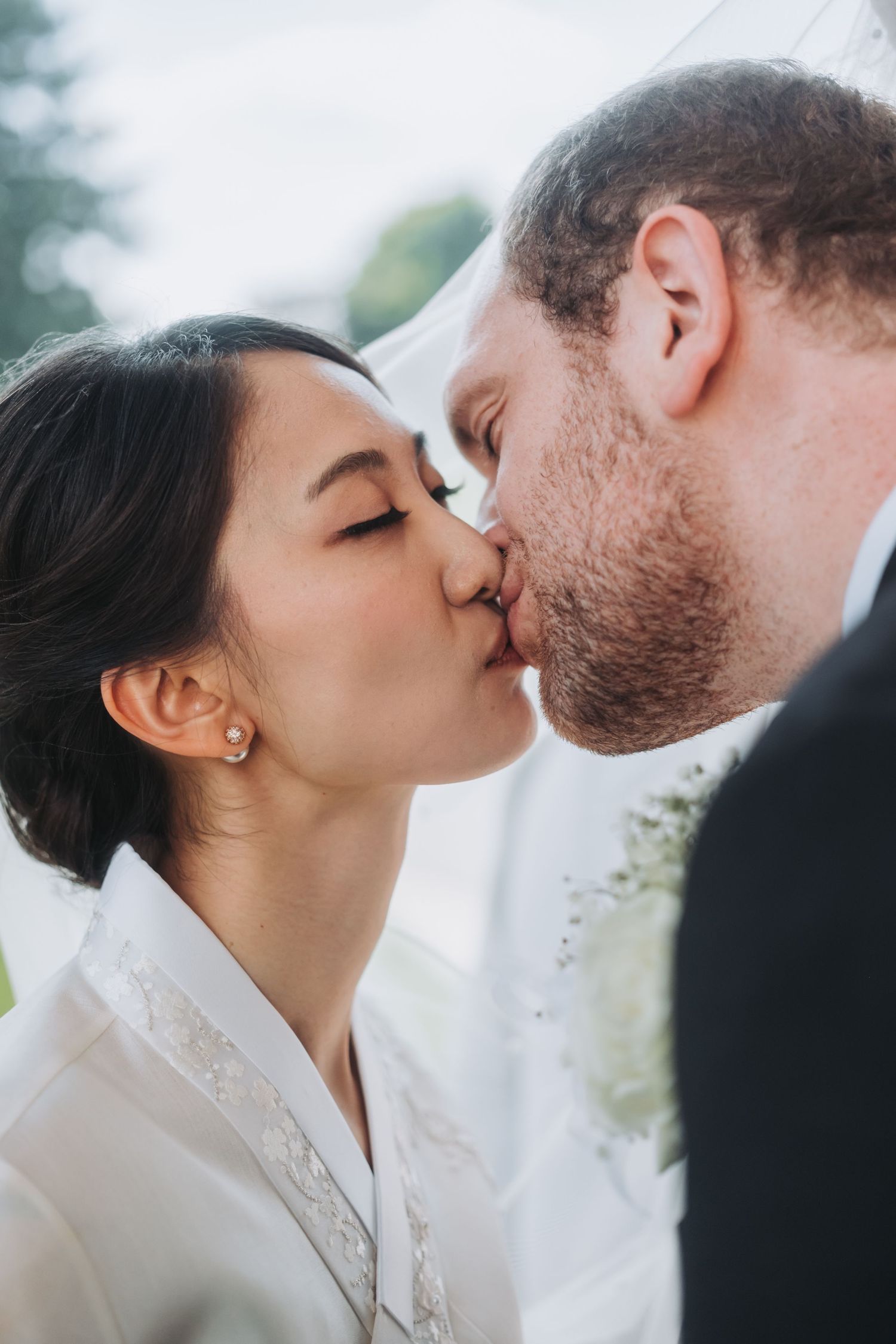 Romantic close-up shot of a couple sharing an intimate moment outdoors.