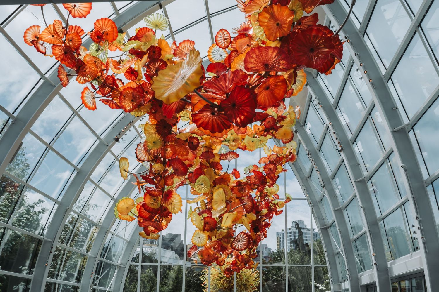 Stunning glass ceiling installation with vibrant orange and red glass sculptures.