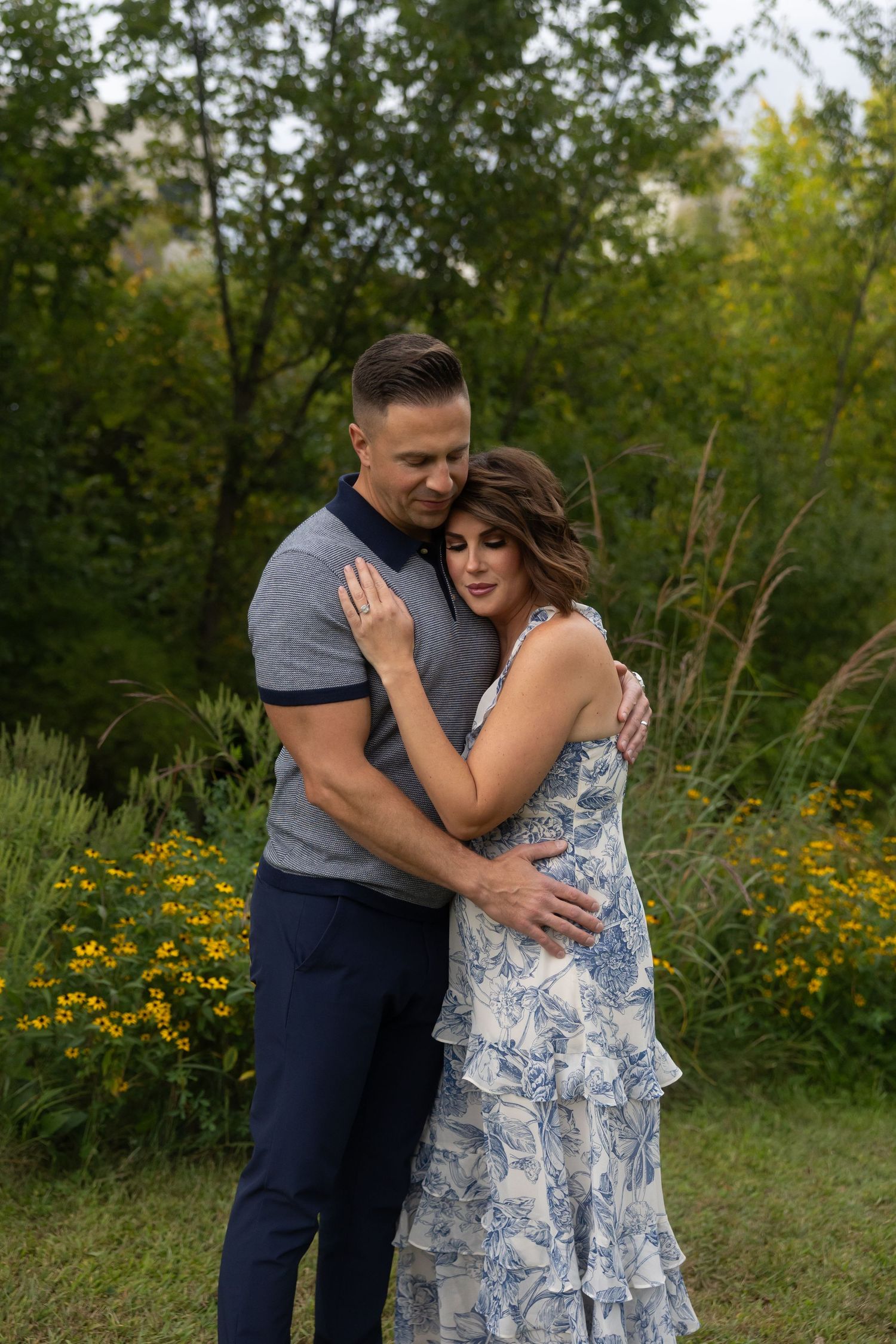 Romantic couple embracing in a field of wildflowers during golden hour.