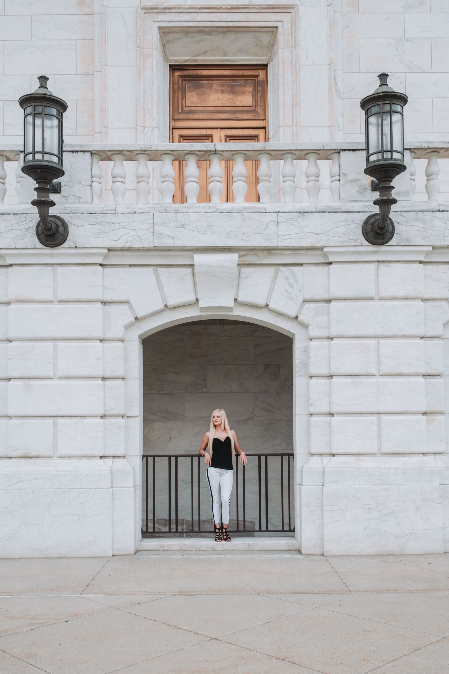A classic white stone building facade with ornate lanterns and a small balcony alcove.