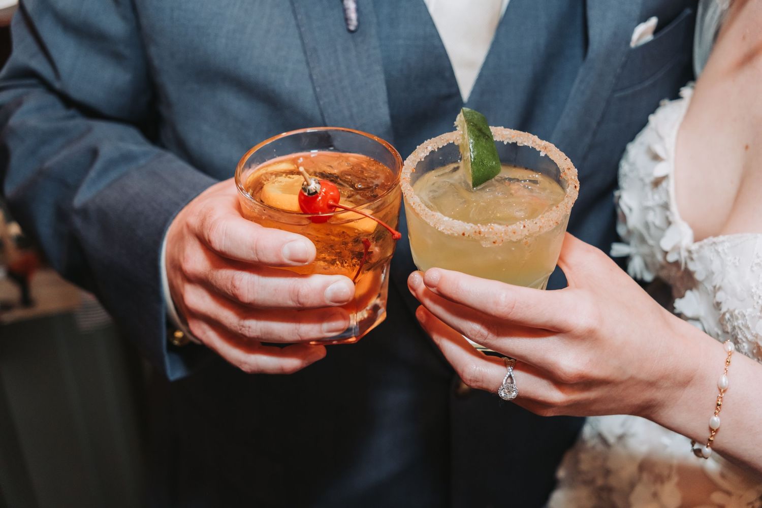 Hands holding colorful cocktail glasses during celebration.