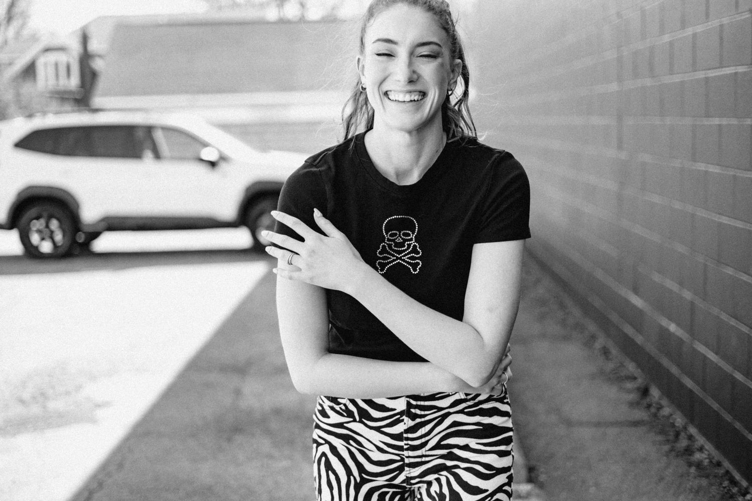 Black and white portrait series against a brick wall background.