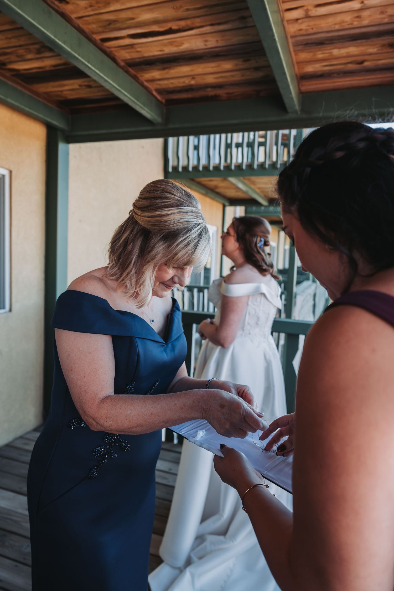 Wedding preparations taking place in a room with wooden ceiling beams.