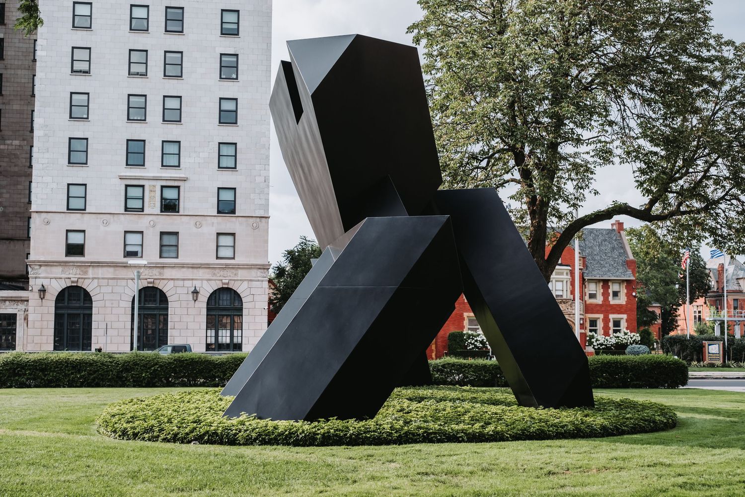 Modern office building exterior with geometric black sculpture in the foreground.